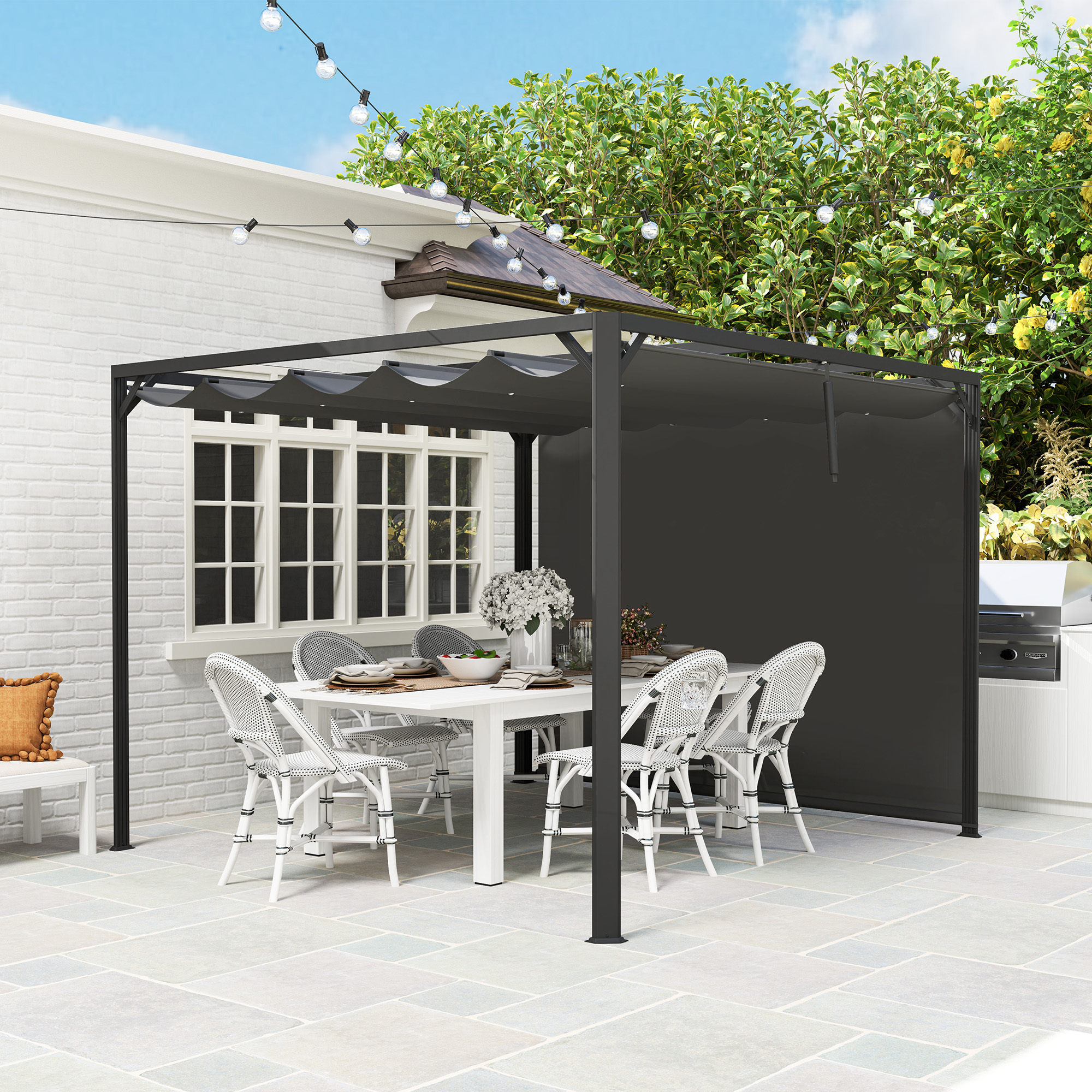 Un comedor exterior cubierto con mesa, sillas, parrilla y guirnalda de luces.