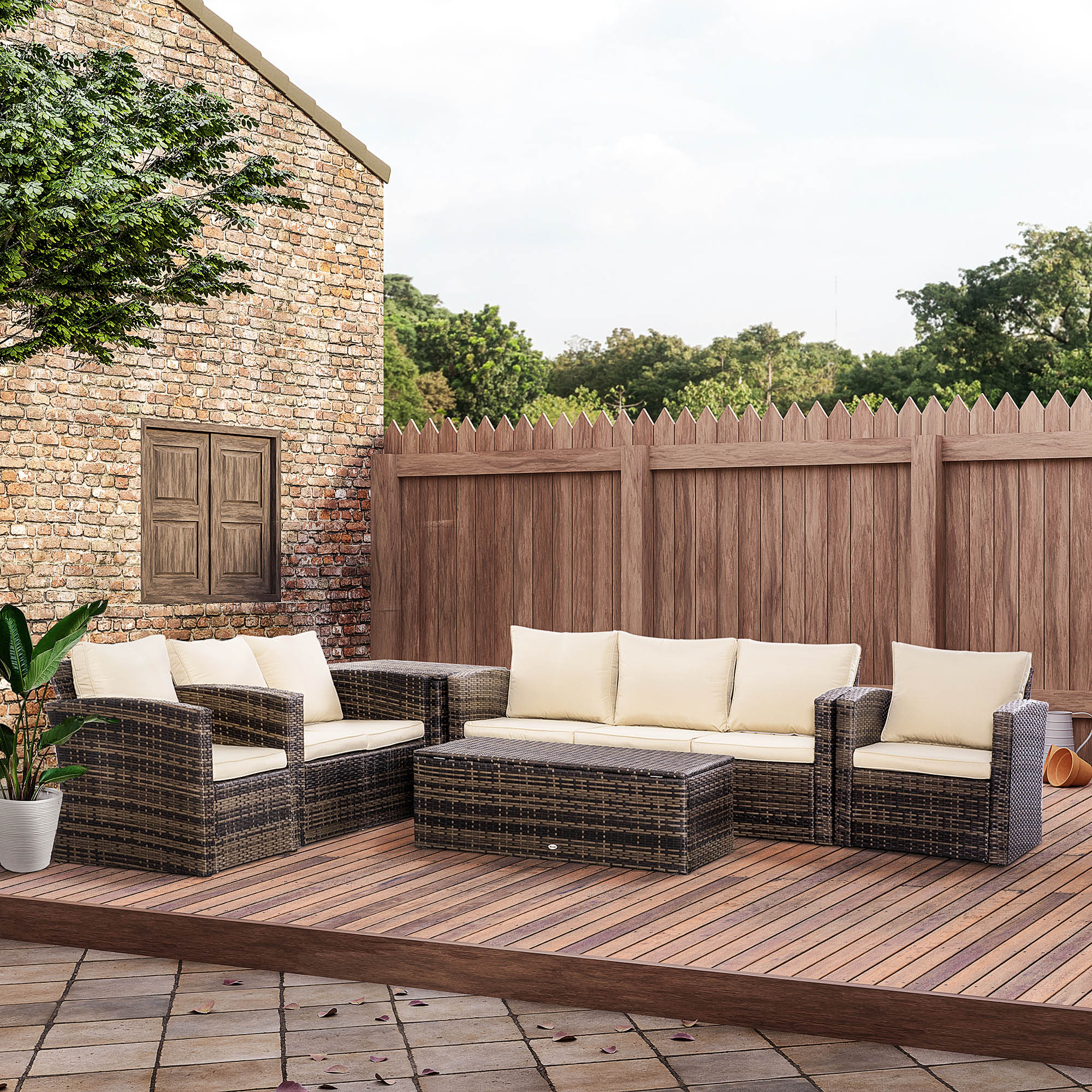 Muebles de mimbre para patio con cojines crema sobre tarima de madera.