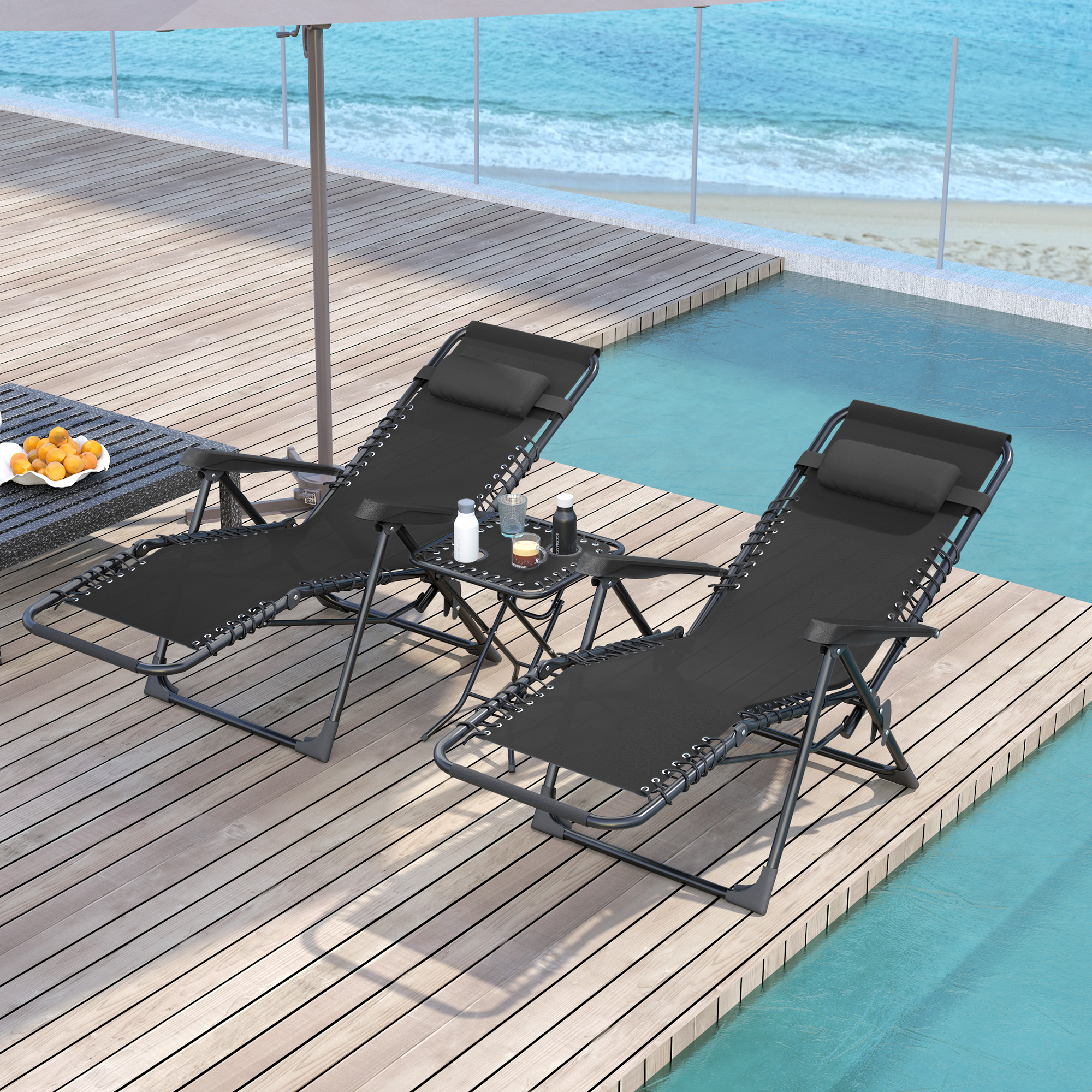Due lettini neri con tavolino a bordo piscina affacciati sul mare.