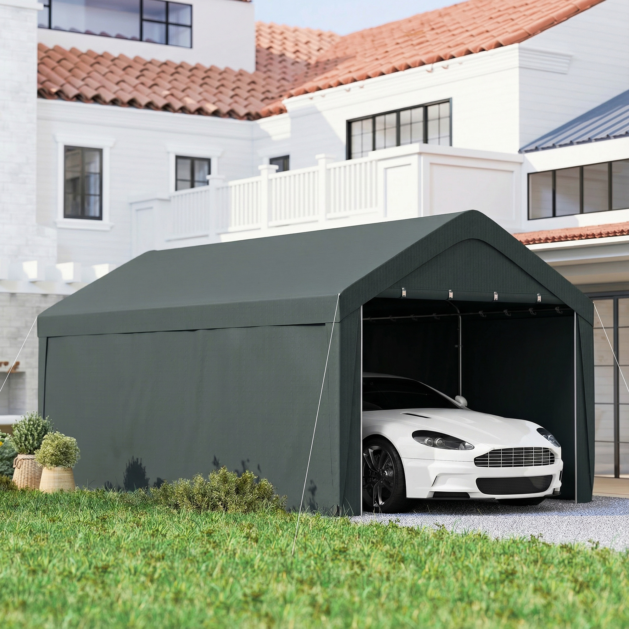 Un cobertizo para autos verde oscuro cubre un auto deportivo blanco frente a casas.