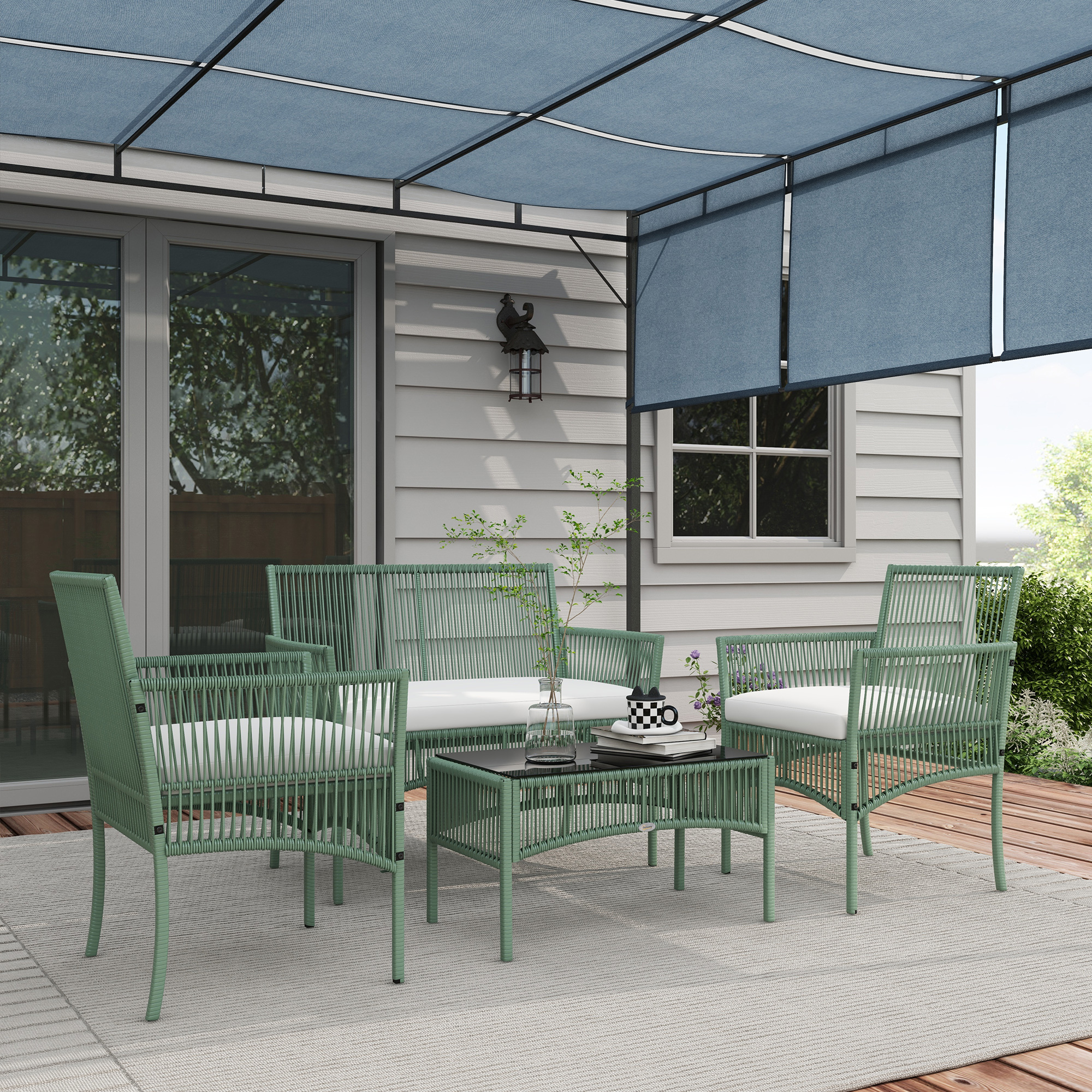 Salotto in rattan verde sotto tettoia blu davanti casa.
