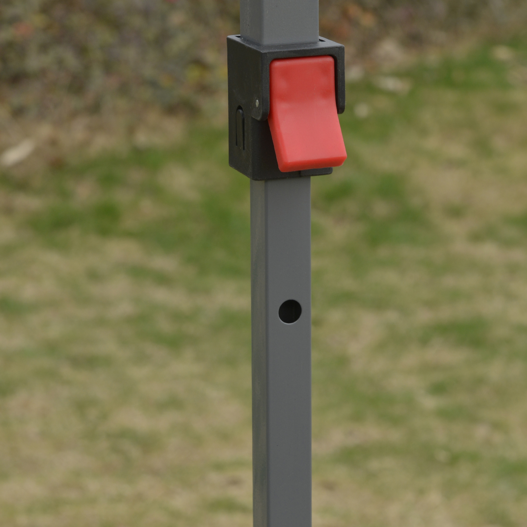 Poste de metal gris con pestillo deslizante rojo y carcasa negra.