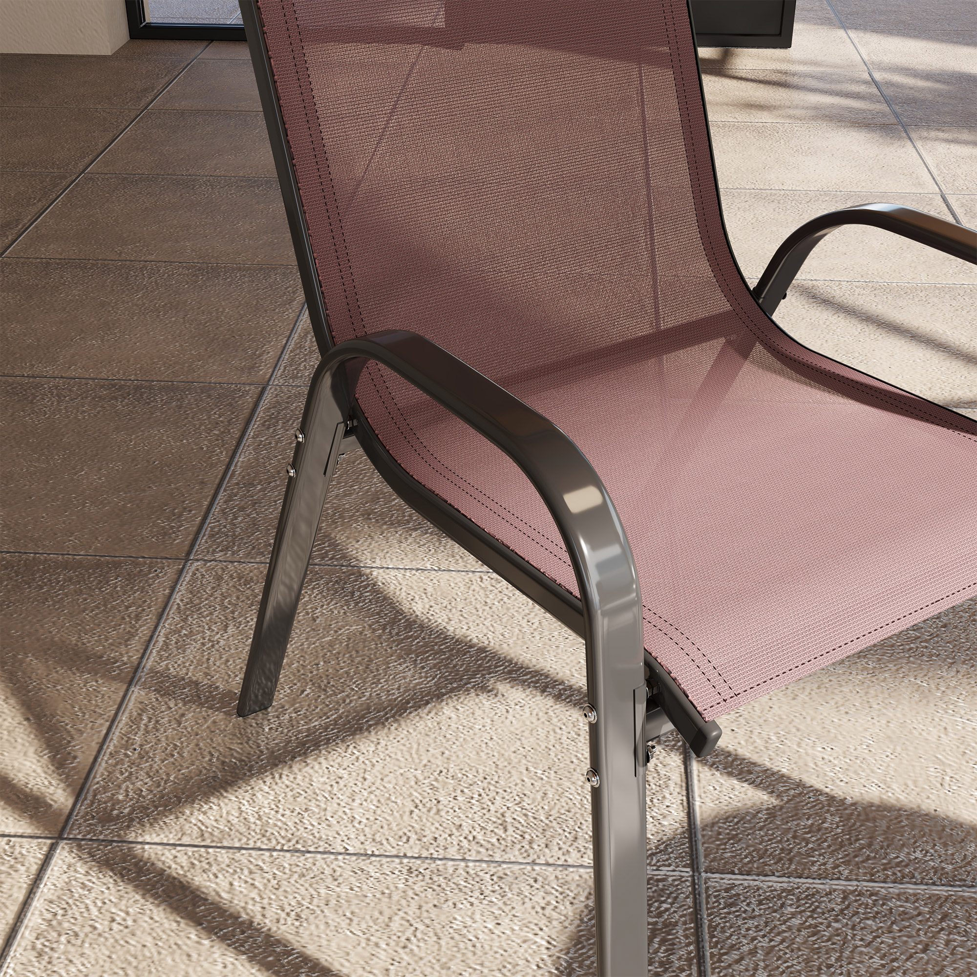Una sedia in rete rosa con telaio in metallo scuro su un patio piastrellato.