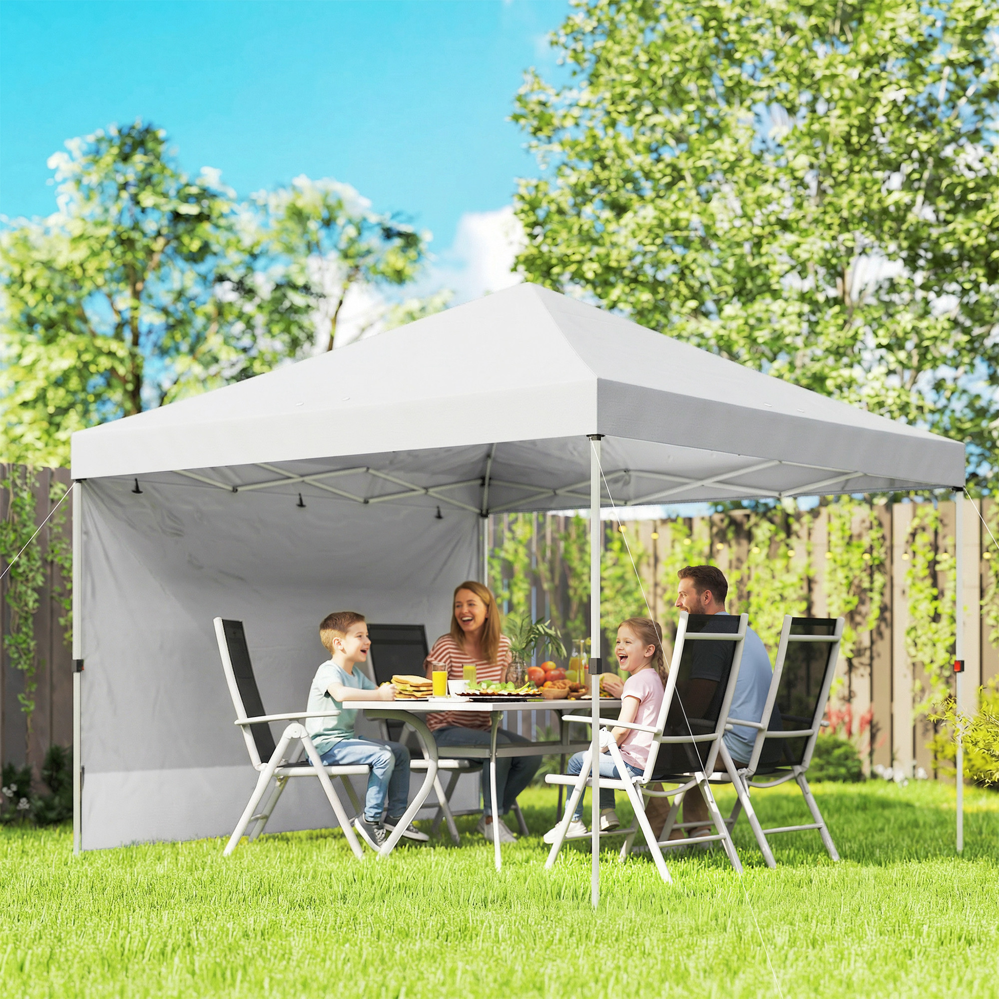 Familia disfruta comida bajo un toldo blanco en patio.