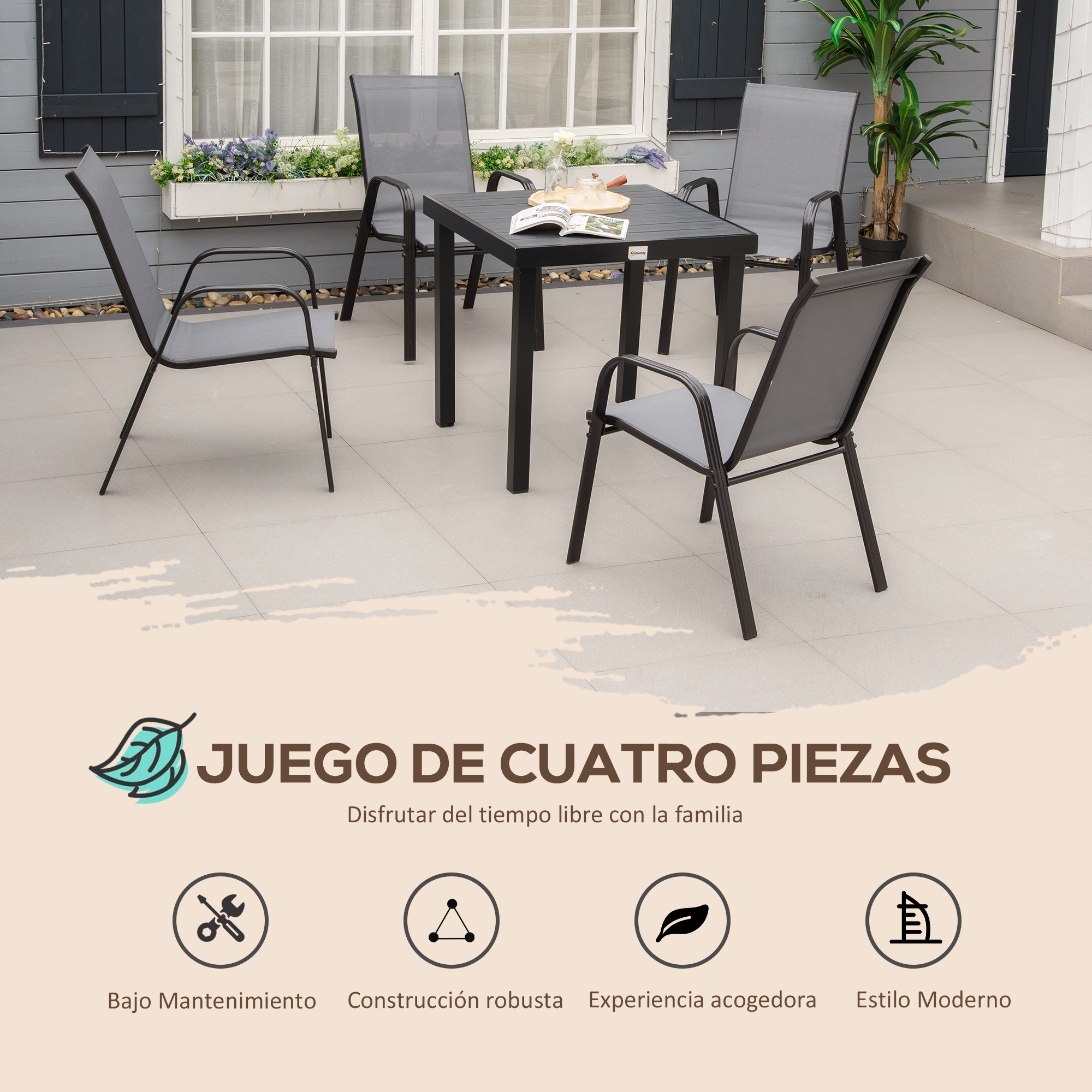 Una mesa negra y cuatro sillas grises en un patio embaldosado junto a una casa.