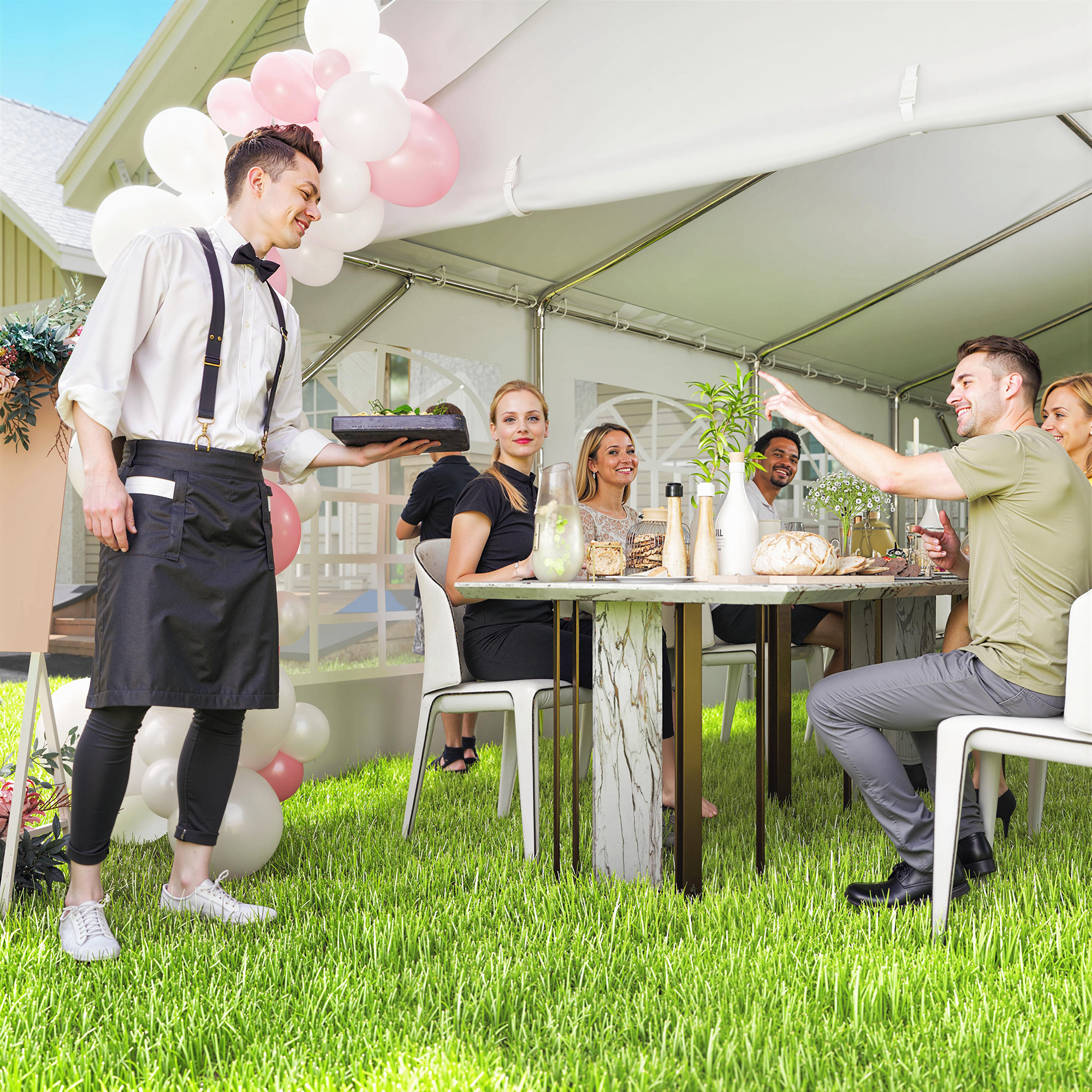Un camarero sirve comida a una mesa exterior con invitados y globos.