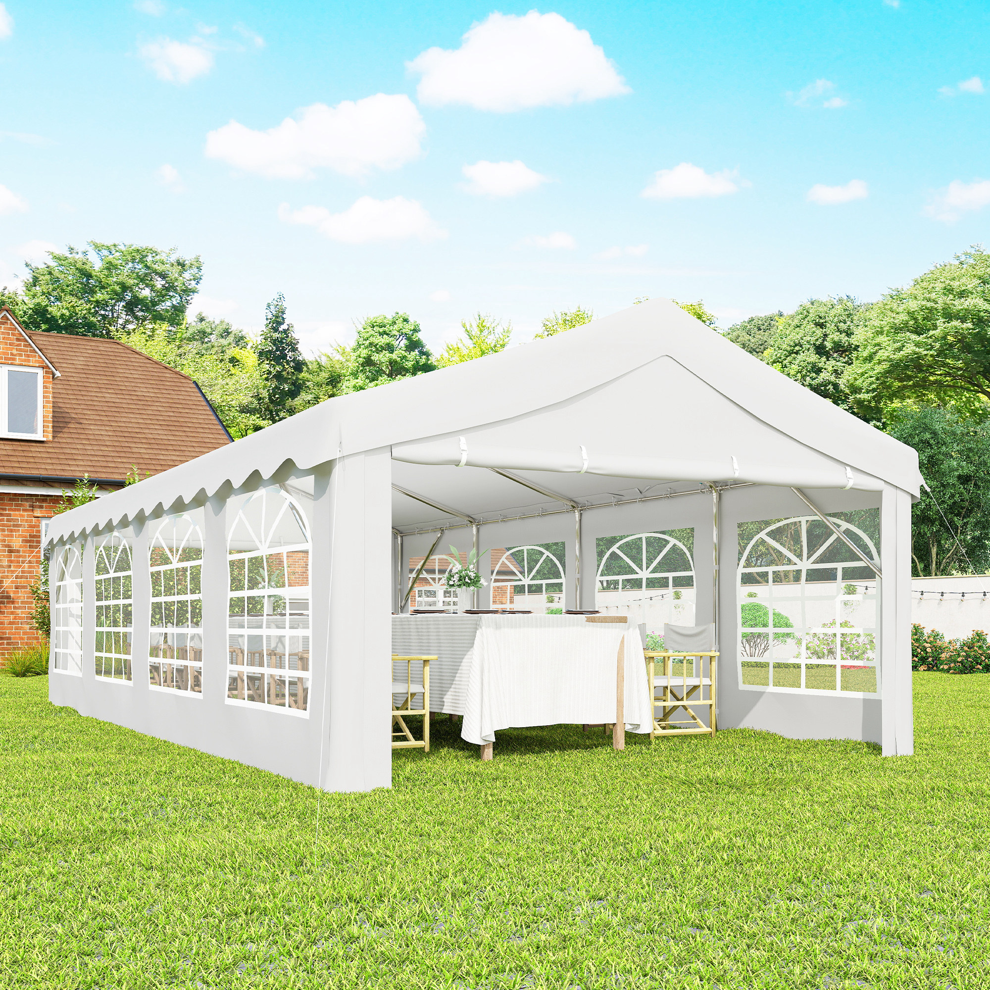Una carpa blanca con ventanas se alza sobre un césped verde, junto a una casa.