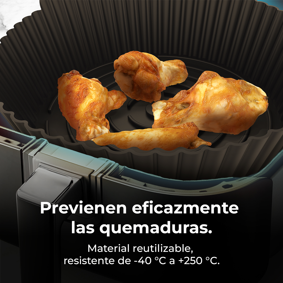 Ali di pollo cotte in un rivestimento nero per friggitrice ad aria.