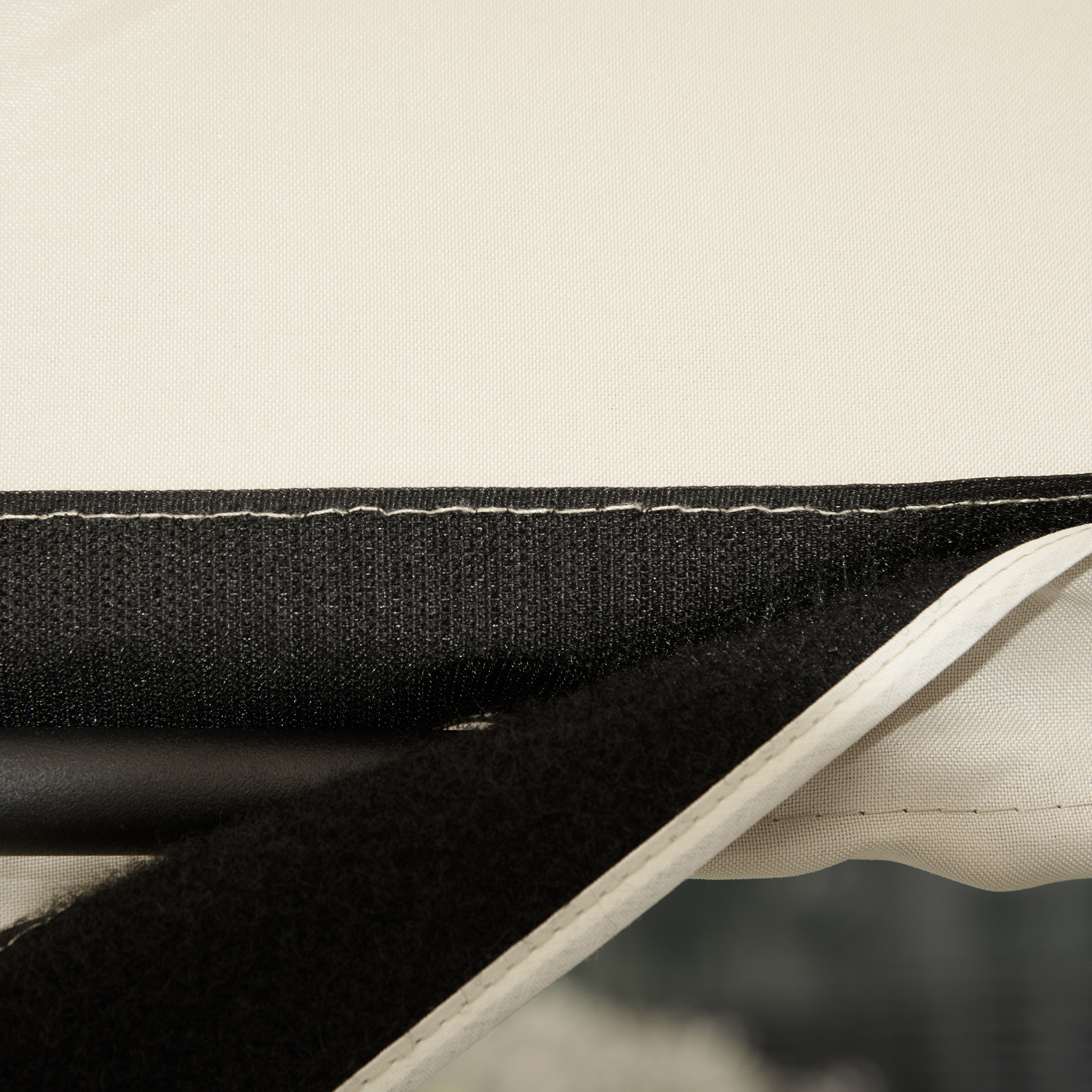Tessuto beige con velcro nero e cuciture.