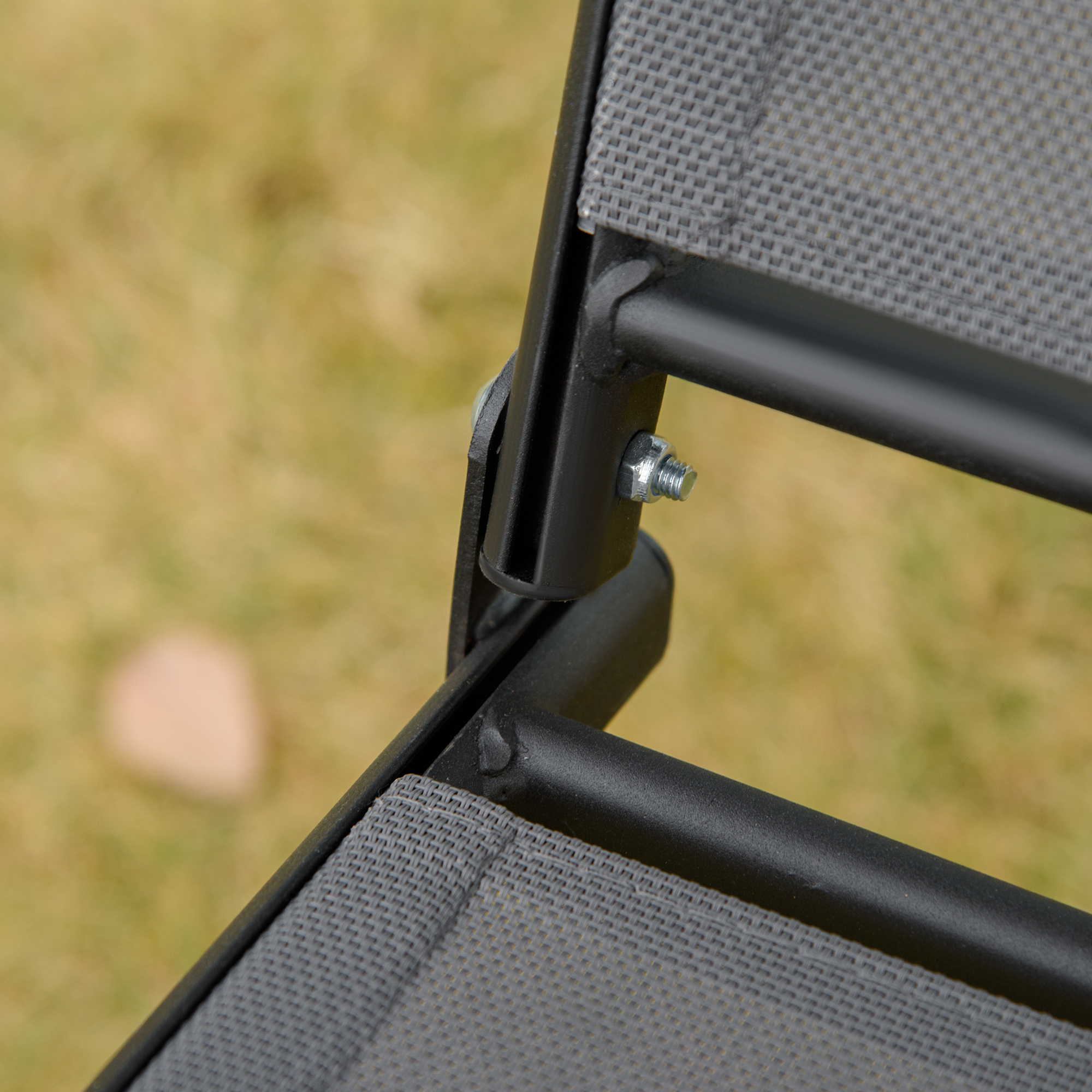 Tejido gris y marco de metal negro de una silla con ensamblaje de tornillo.