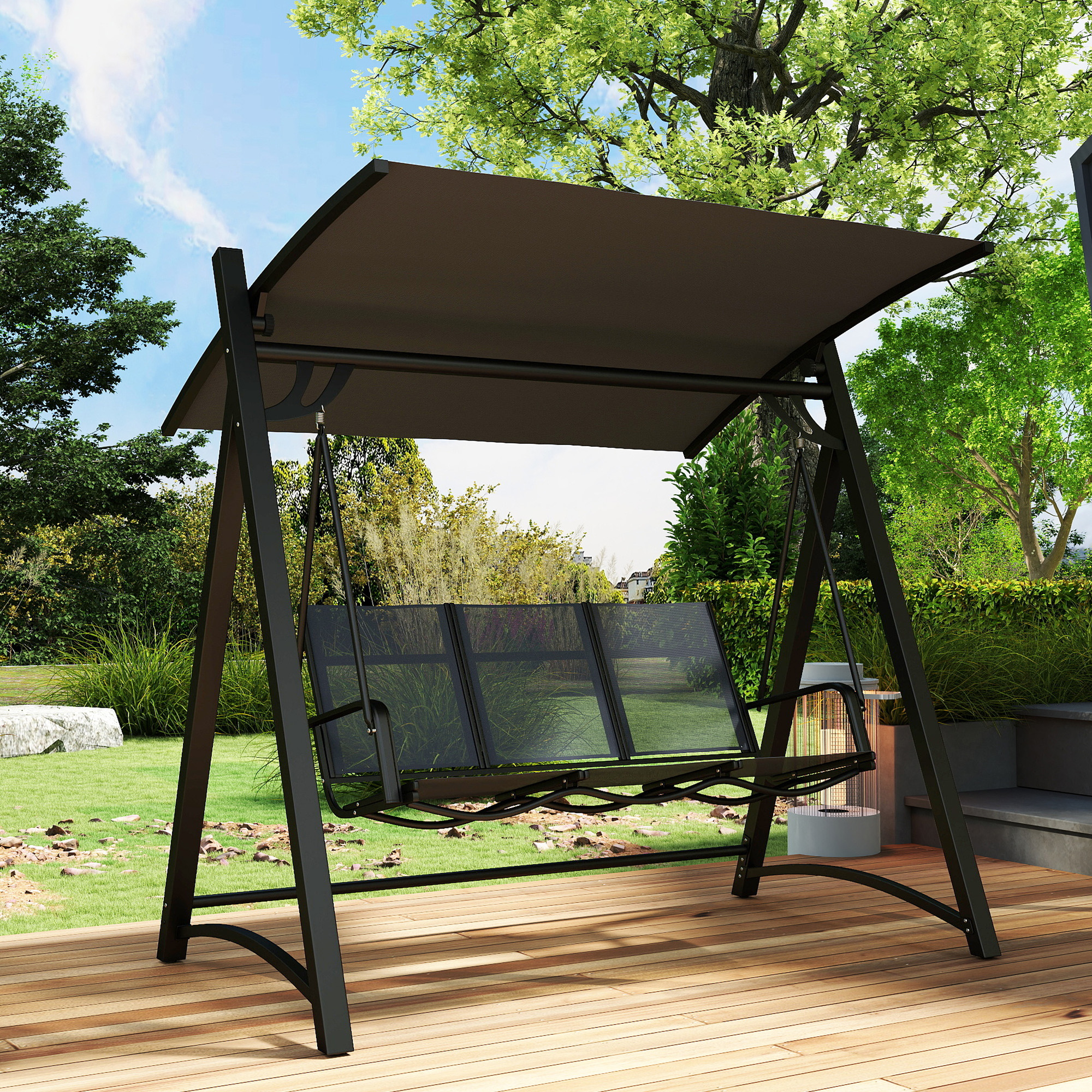 Un columpio negro con toldo marrón se asienta sobre una terraza de madera al aire libre.