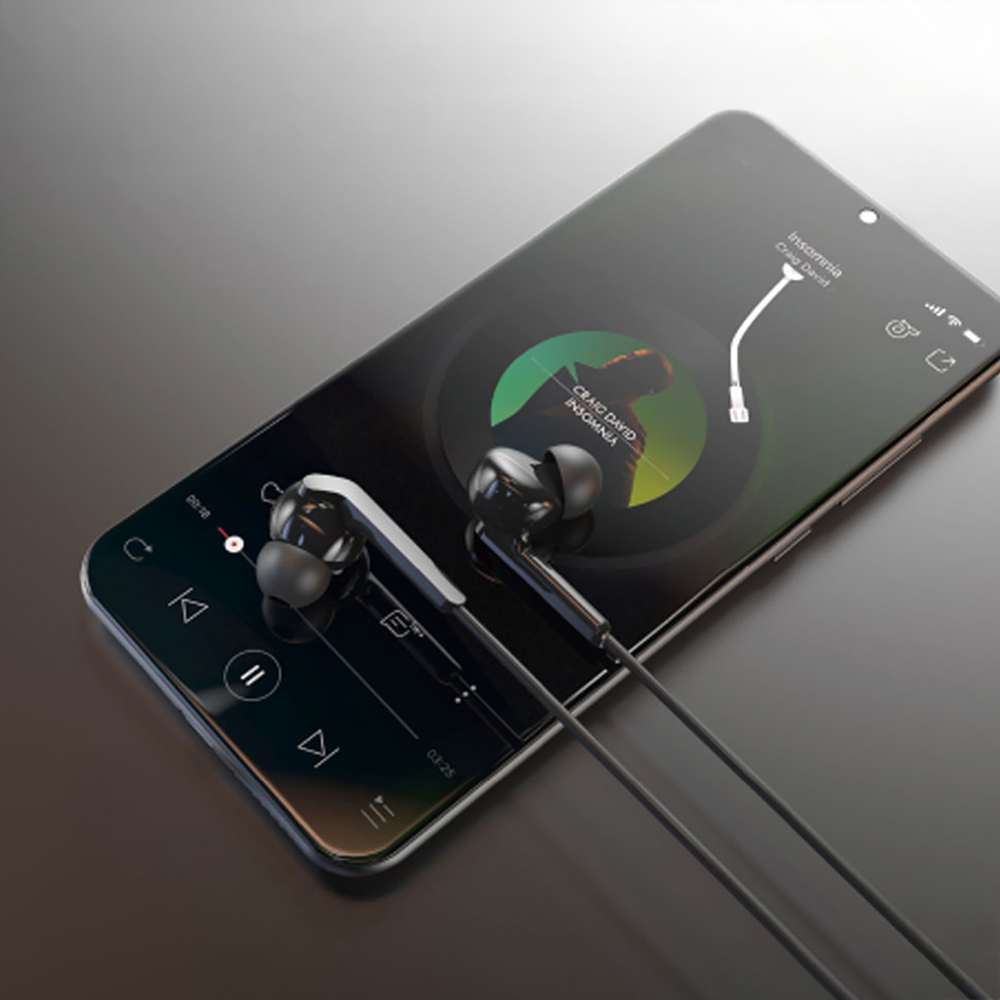 Auricolari neri su smartphone con interfaccia lettore musicale.