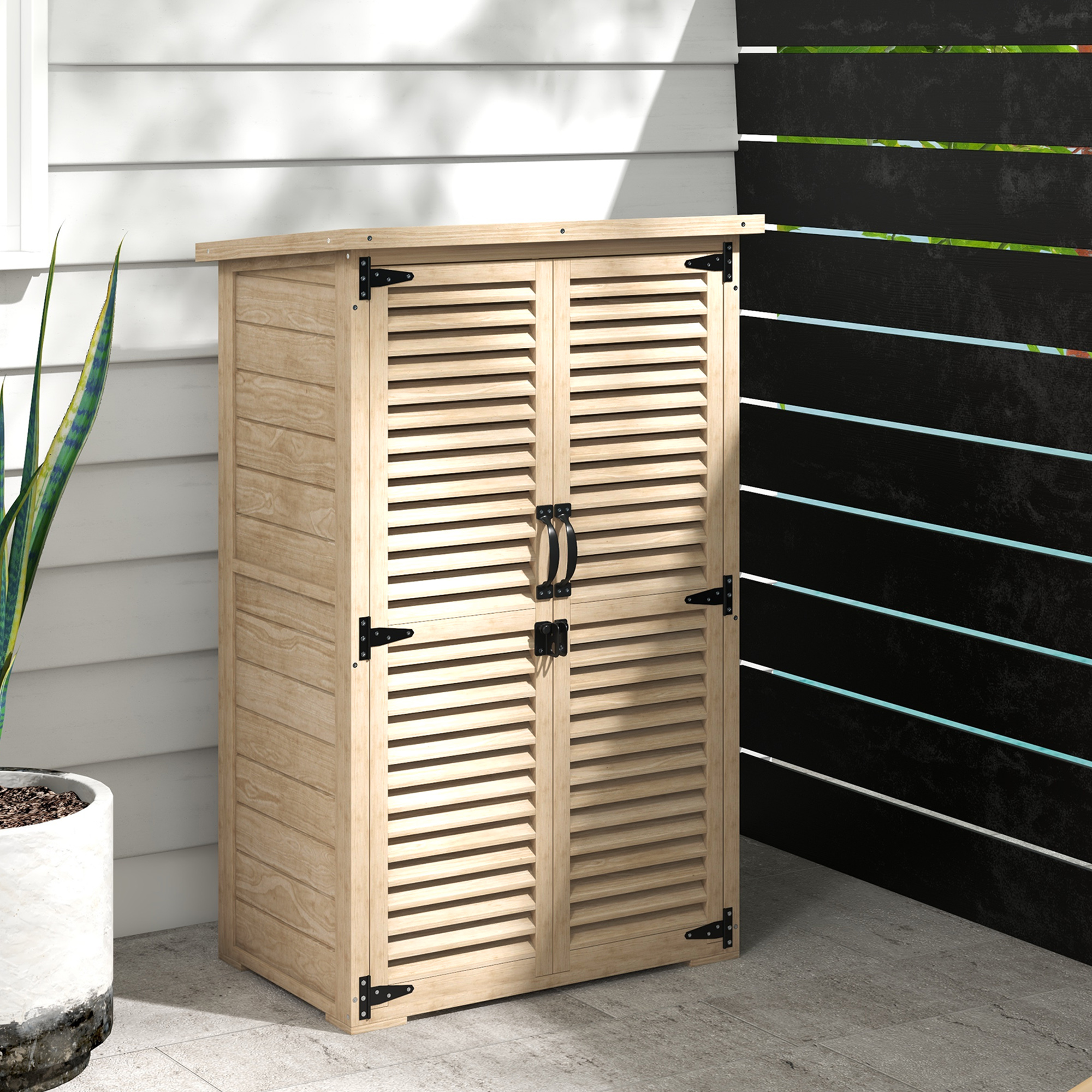 Un armario de madera con puertas de lamas está en un patio junto a una planta.