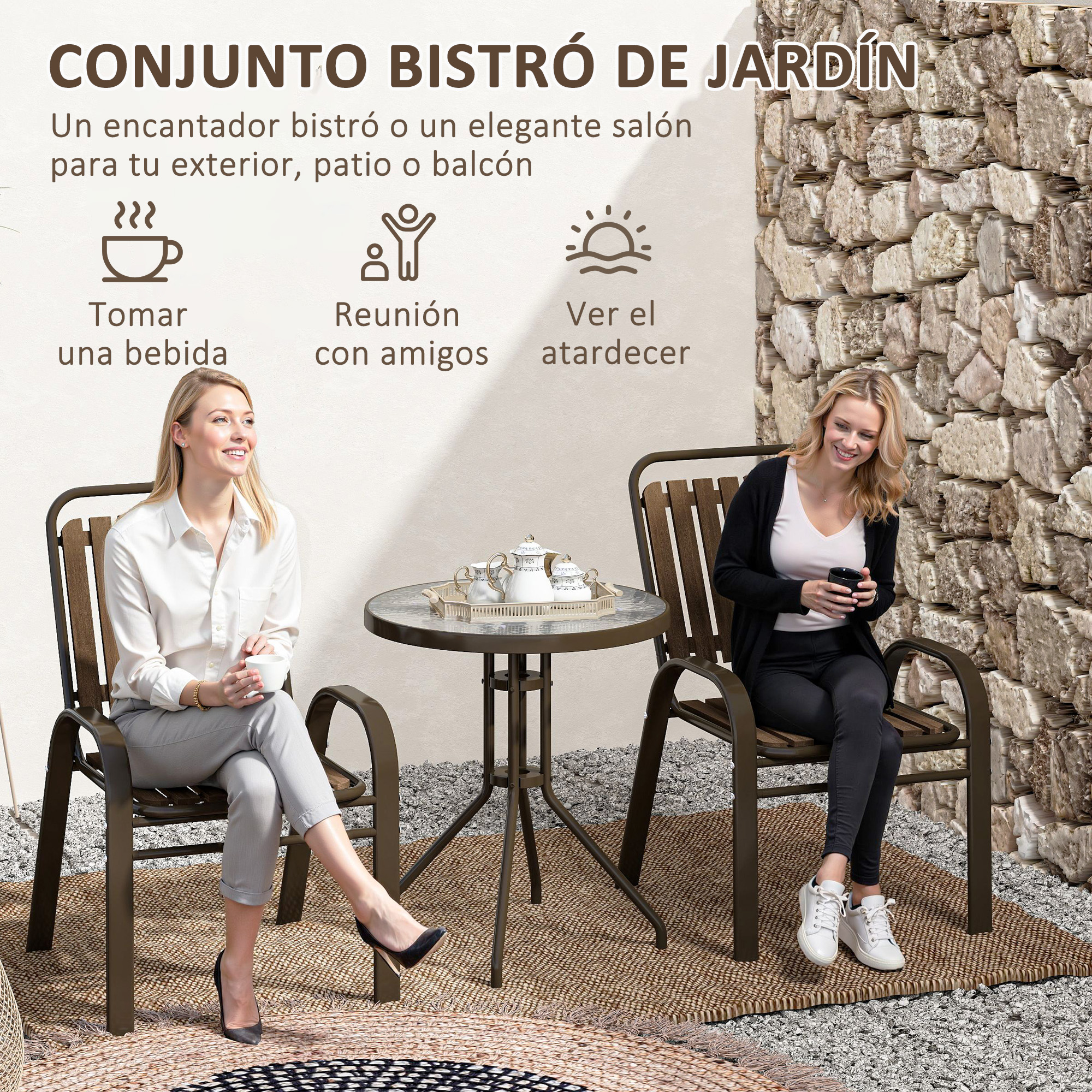 Dos mujeres sentadas en sillas de patio junto a una mesa, con pared de piedra detrás.