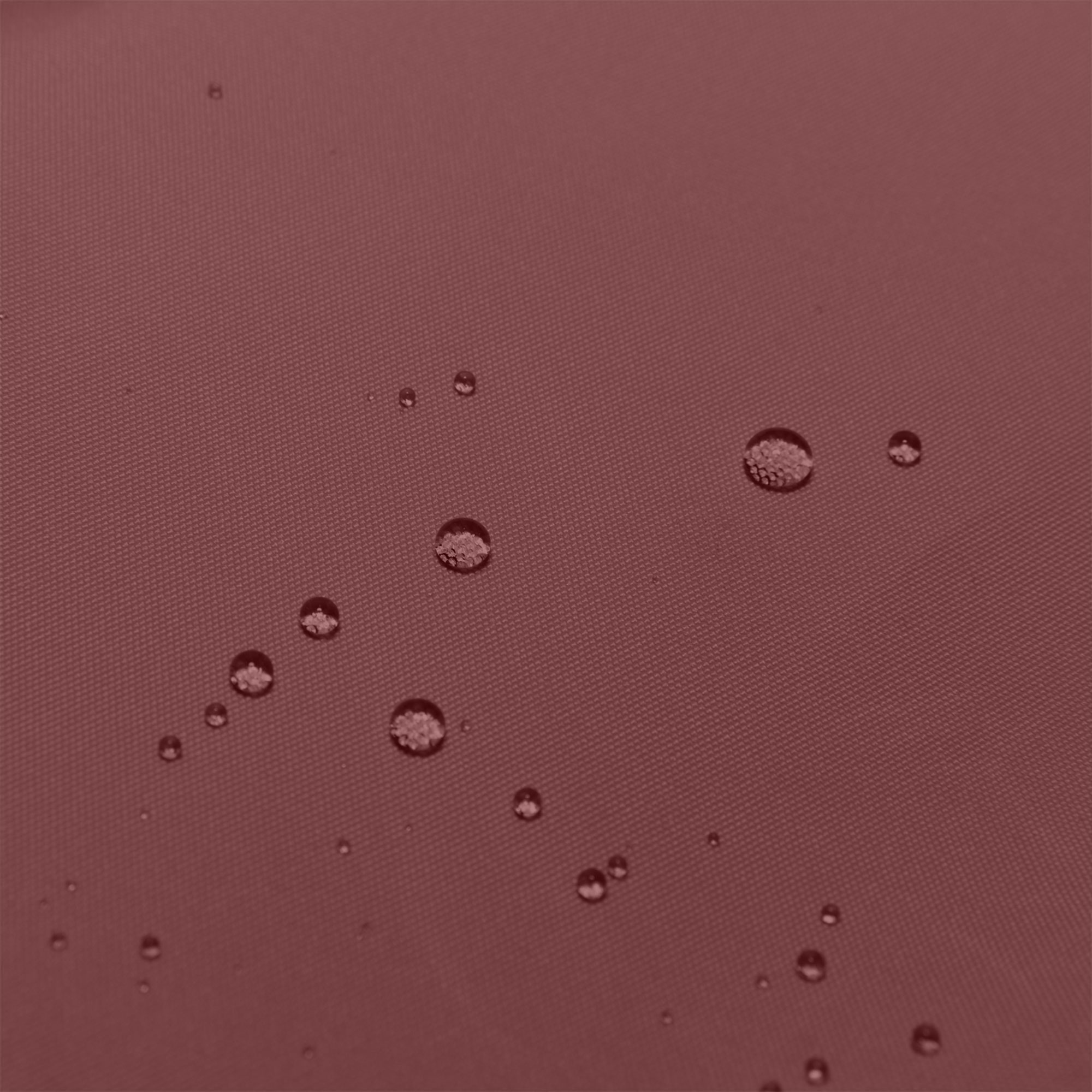 Gotas de agua sobre una superficie texturizada de color granate.