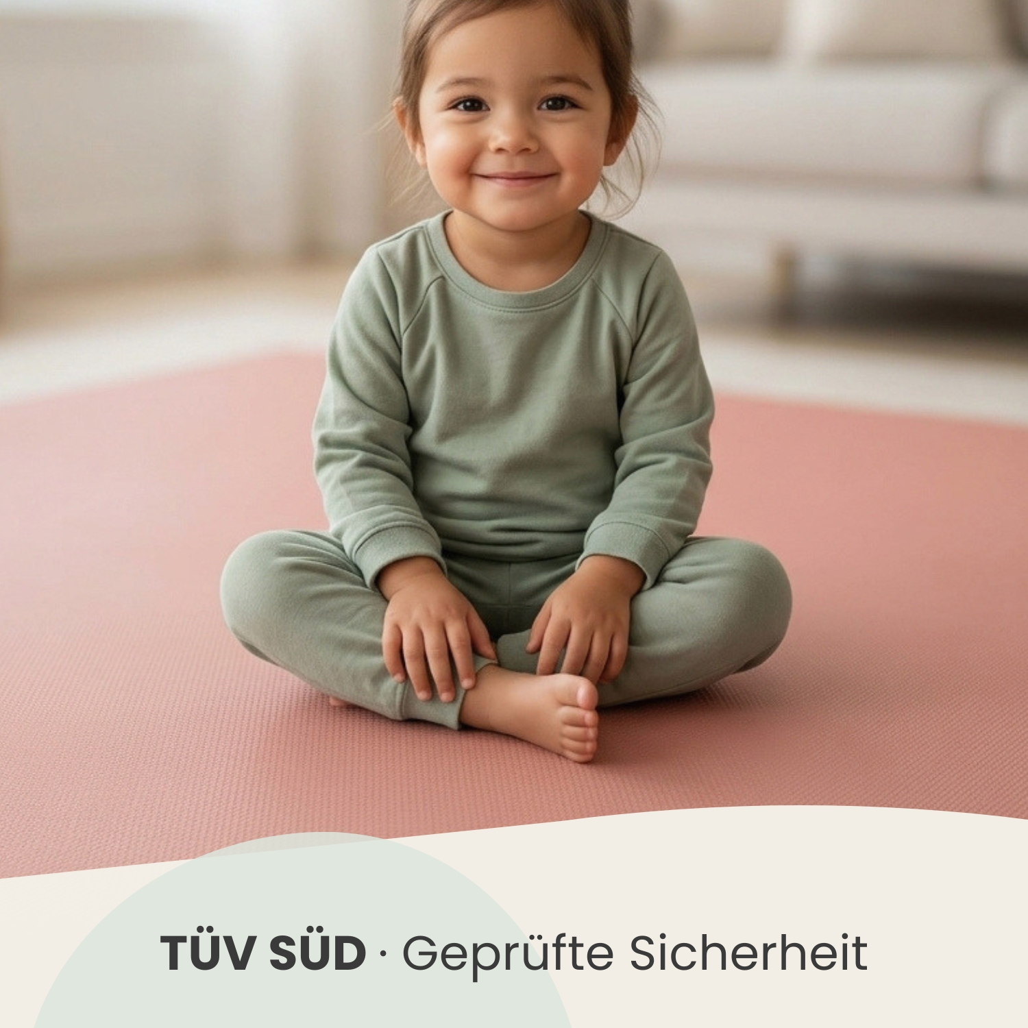 Ein kleines Kind sitzt im Schneidersitz auf einer rosafarbenen Matte.