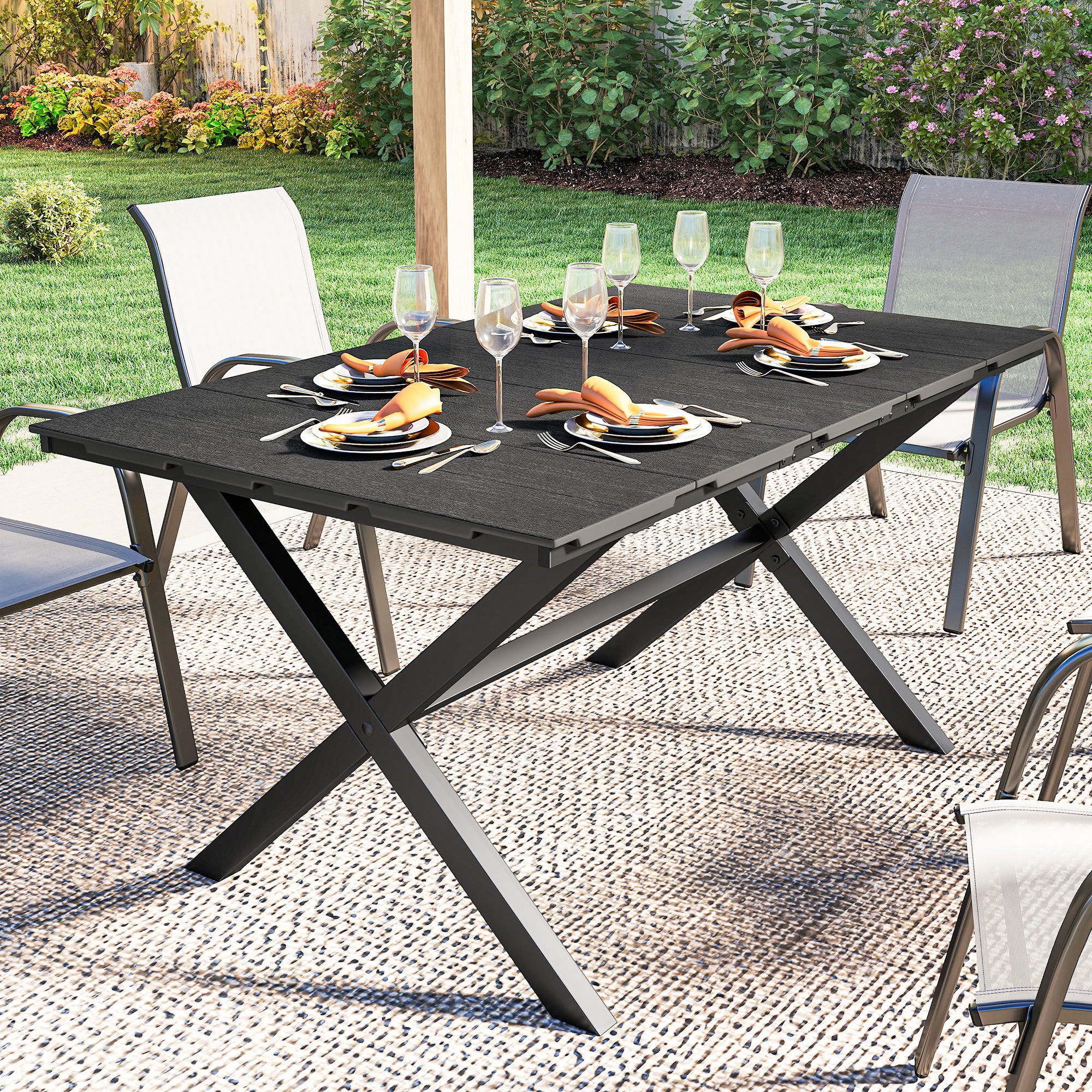 Una mesa de comedor negra para exteriores con ajustes de lugar y sillas, rodeada de vegetación.