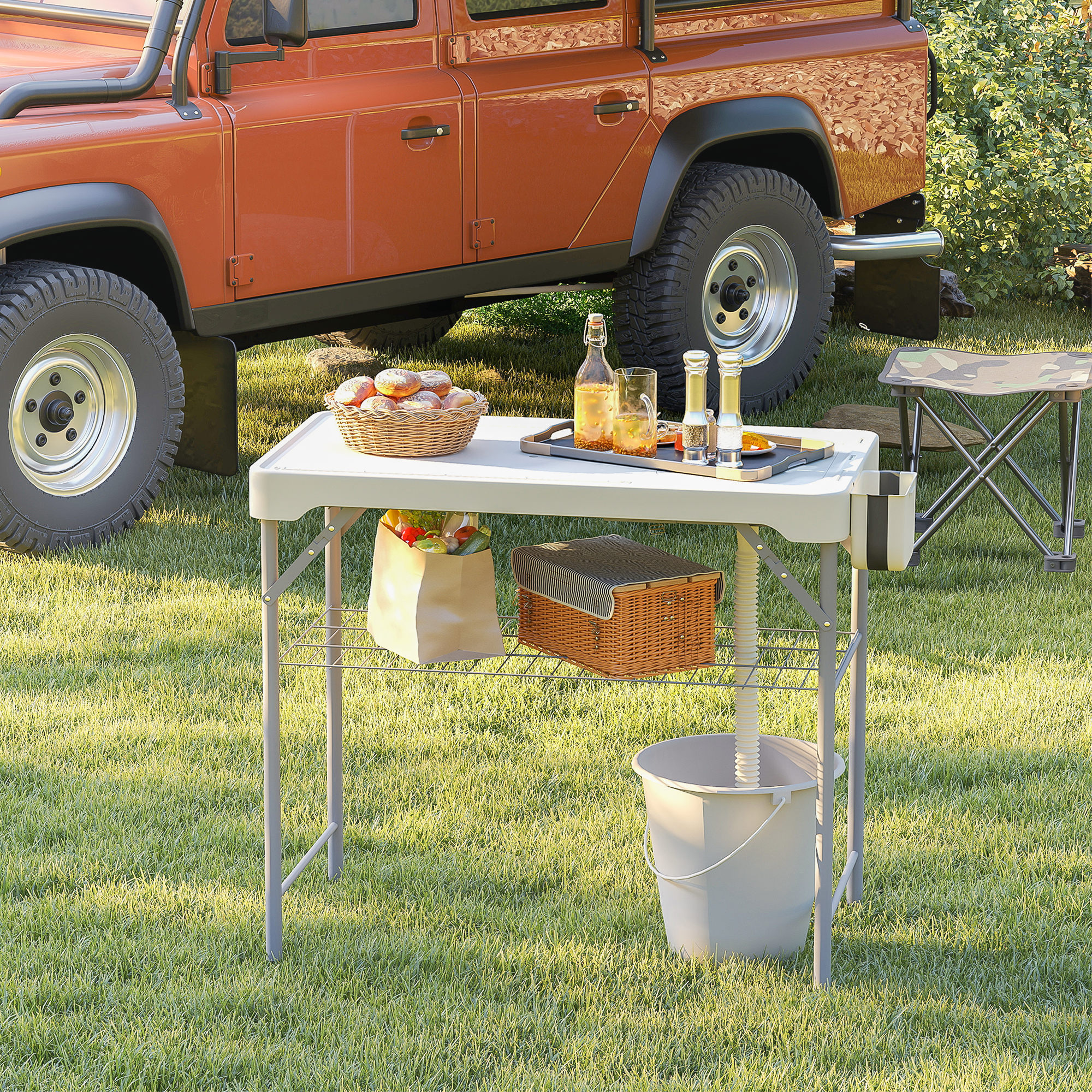 Un todoterreno naranja junto a una mesa de picnic con comida y un cubo.