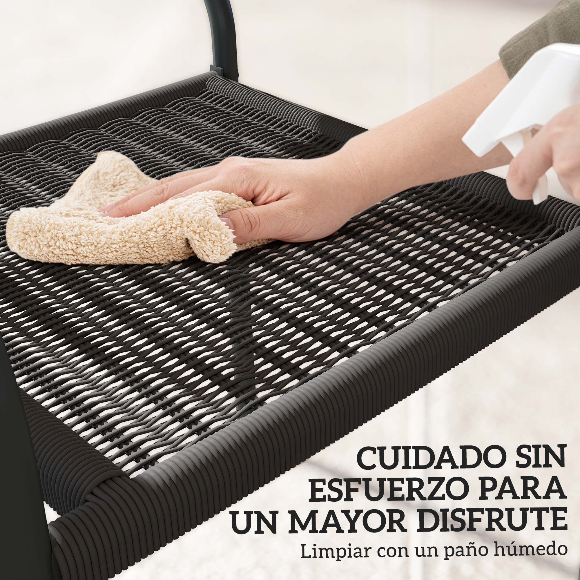 Una mano limpia un tejido de ratán negro con un paño beige.