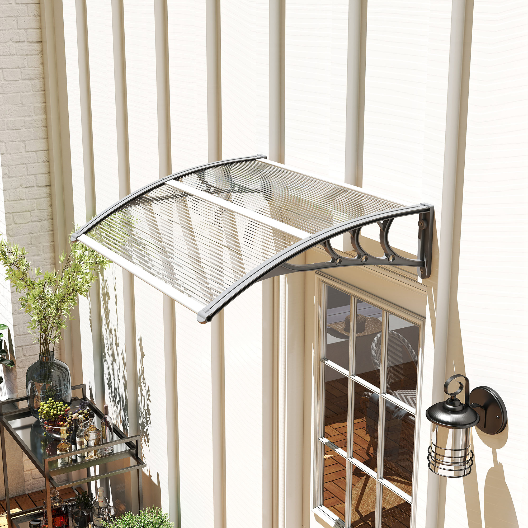 Un toldo sobre una puerta con ventana y una mesa auxiliar con botellas y frutas.