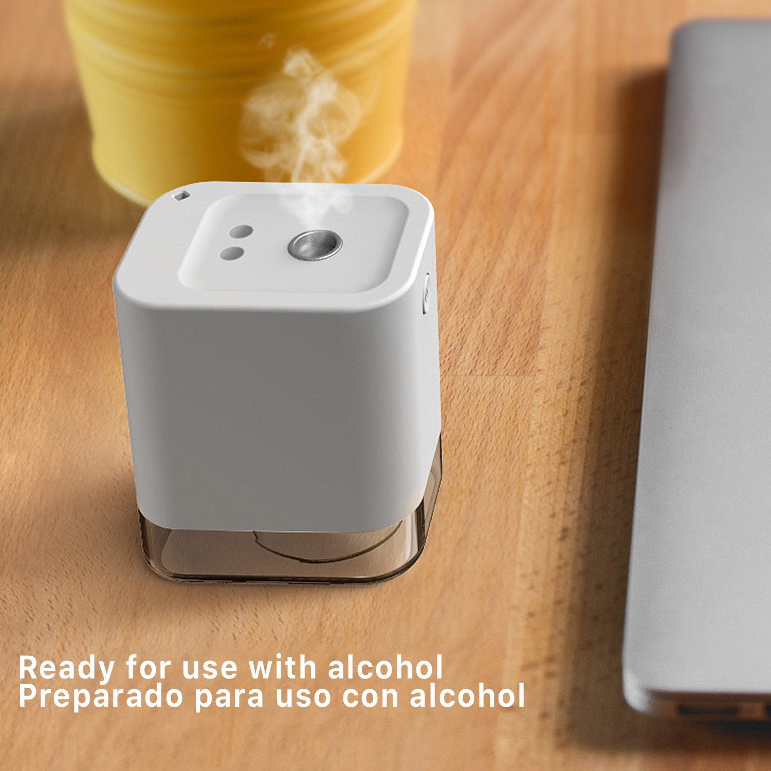 Un vaporizador blanco sobre mesa de madera, emite vapor. Hay una taza y portátil.