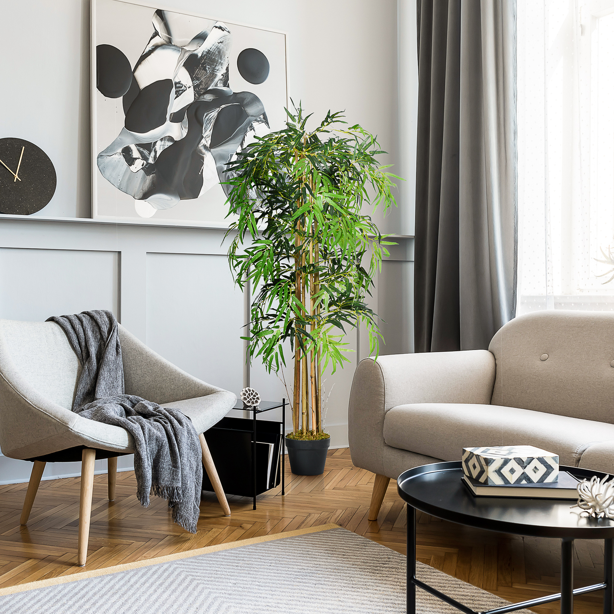 Una sala de estar luminosa con sillón, sofá, planta y cuadro.