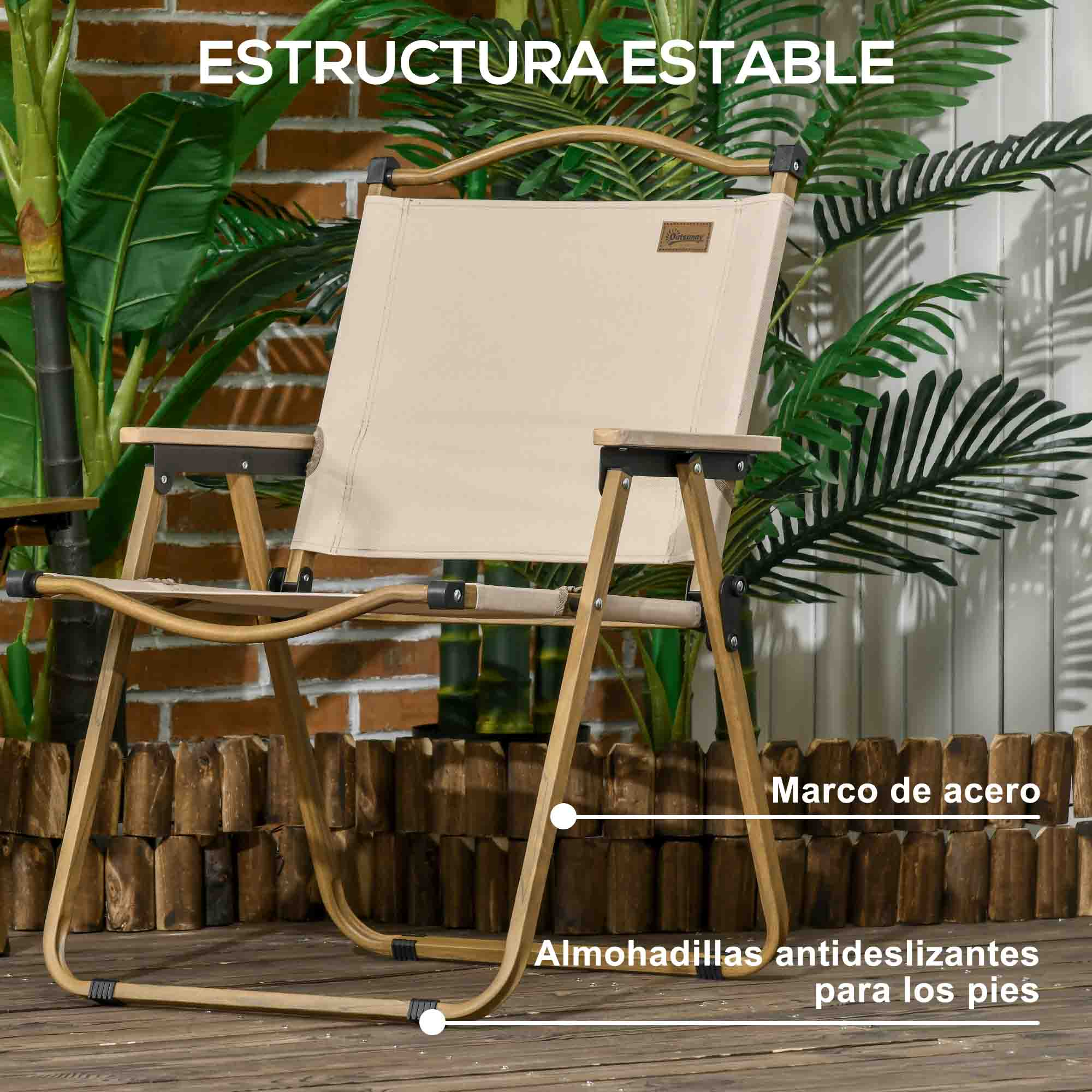 Silla de camping beige con marco de madera y detalles de acero, rodeada de plantas.