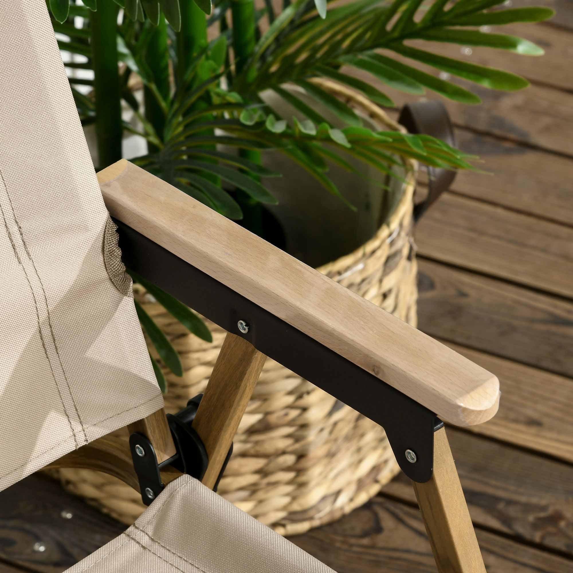 Una silla de tela beige con reposabrazos de madera se asienta en una terraza de madera junto a una cesta tejida con plantas.