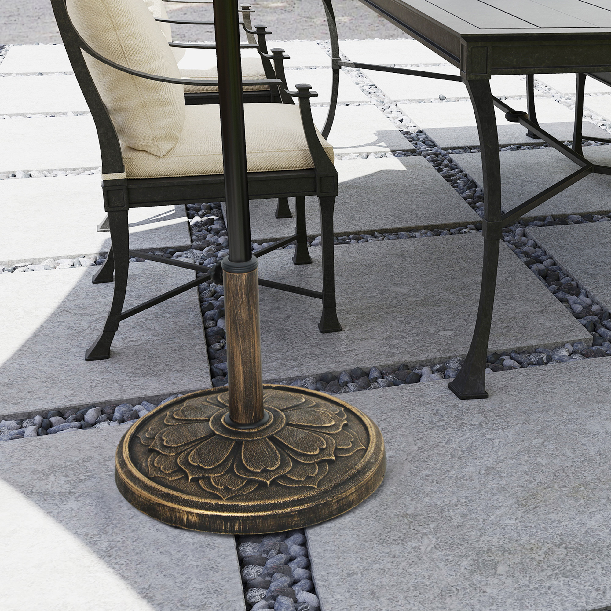 Mesa y sillas de patio con base de sombrilla decorativa en patio de piedra y guijarros.