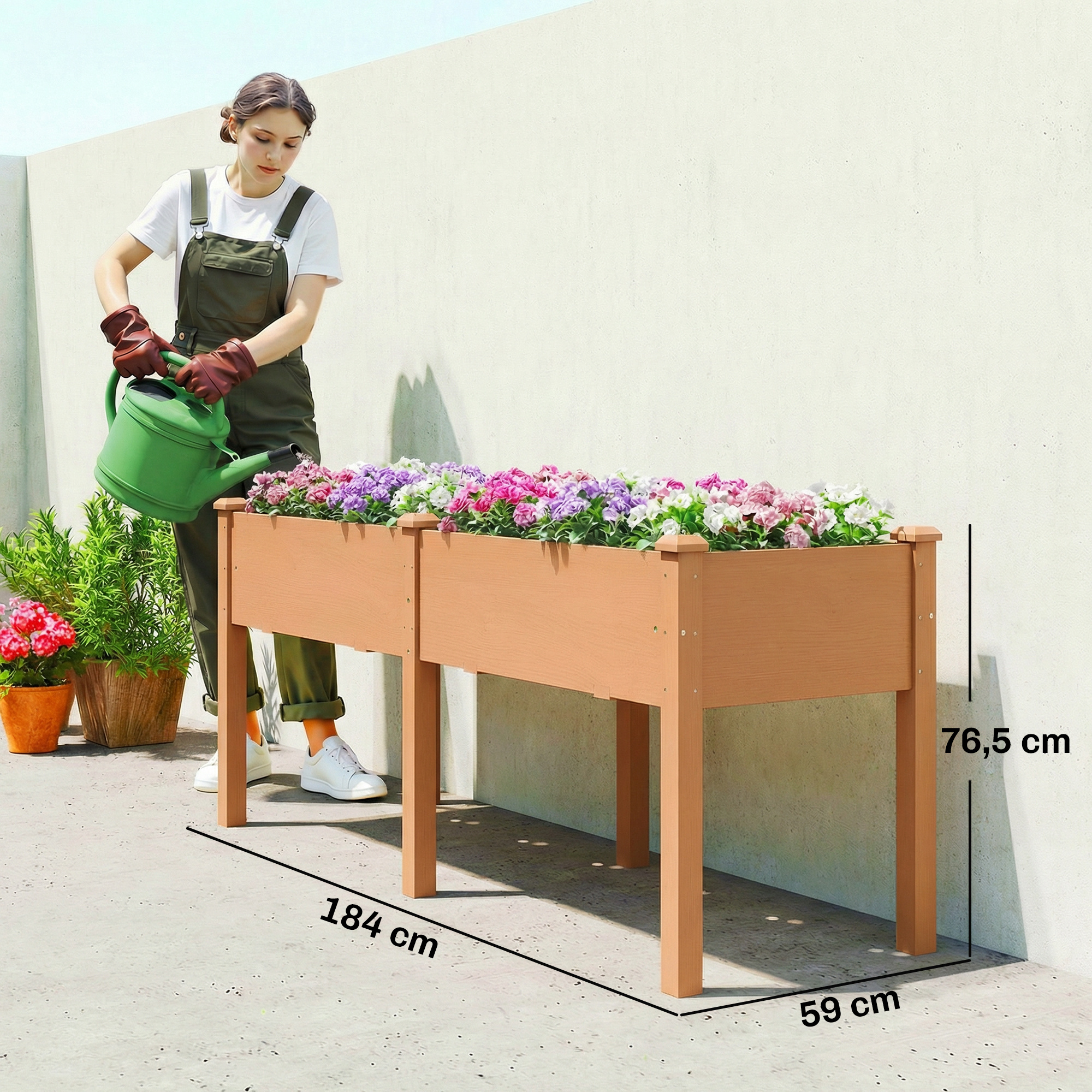 Una mujer riega flores en un bancal elevado con una regadera verde.
