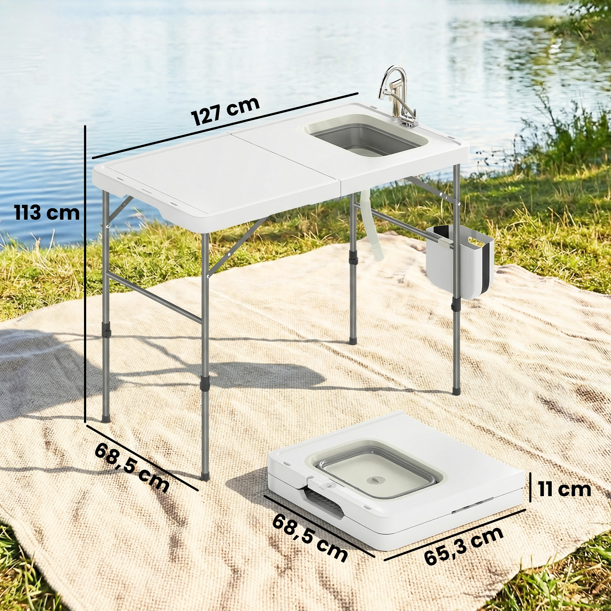 Mesa plegable blanca con fregadero y grifo junto a un lago.