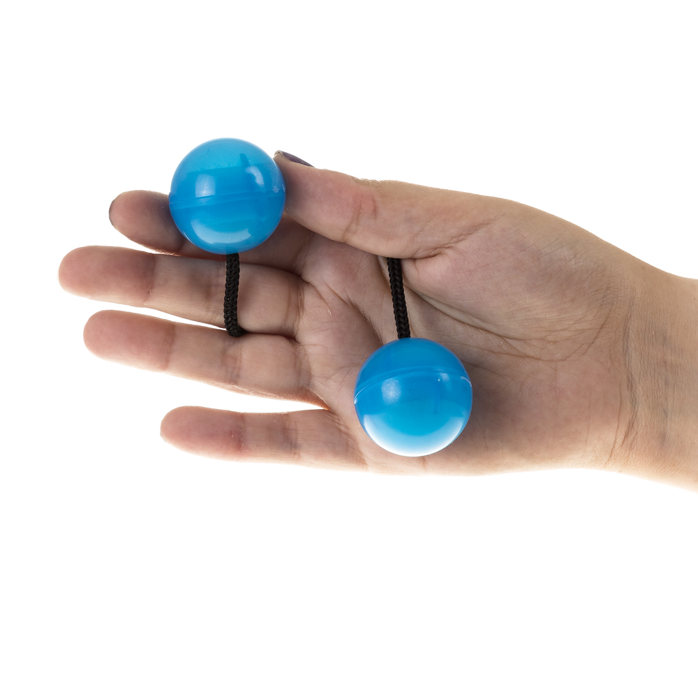 Una mano tiene due palline blu su corde, isolate su sfondo bianco.