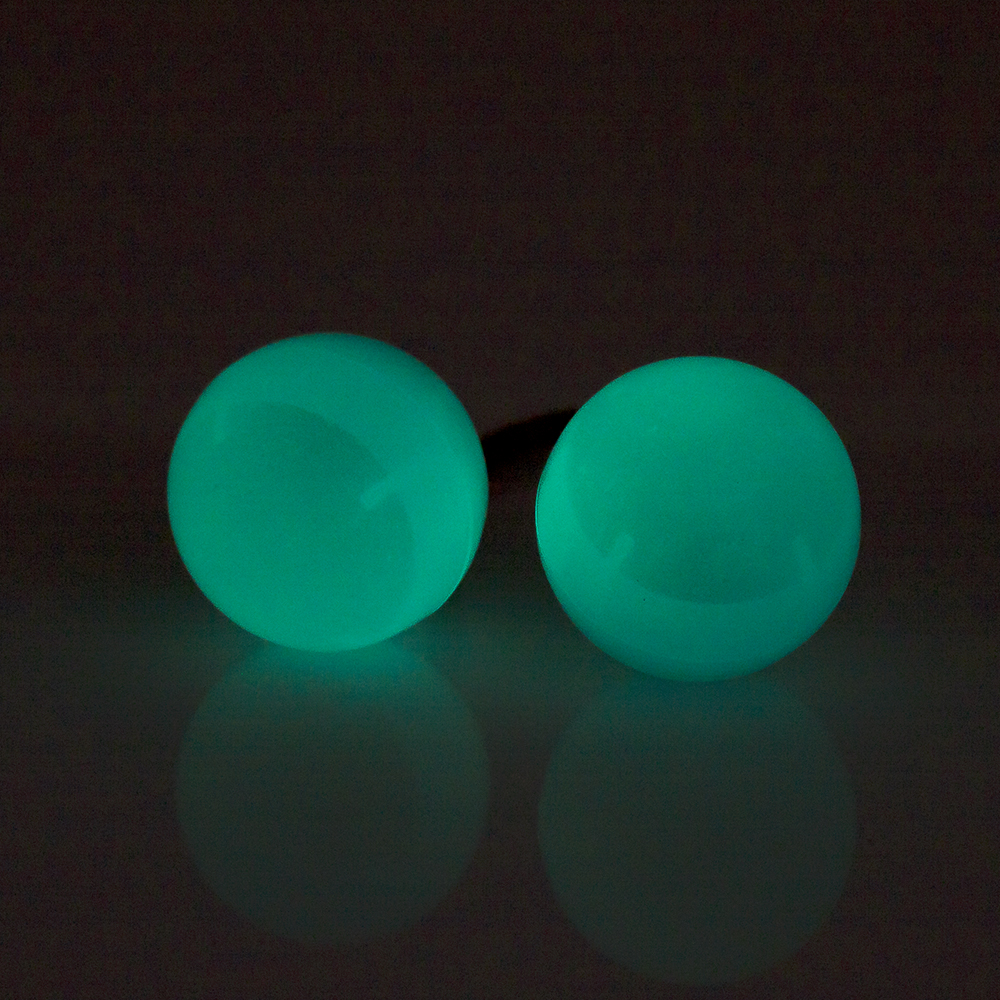 Due sfere turchesi luminose su sfondo scuro, con riflesso.