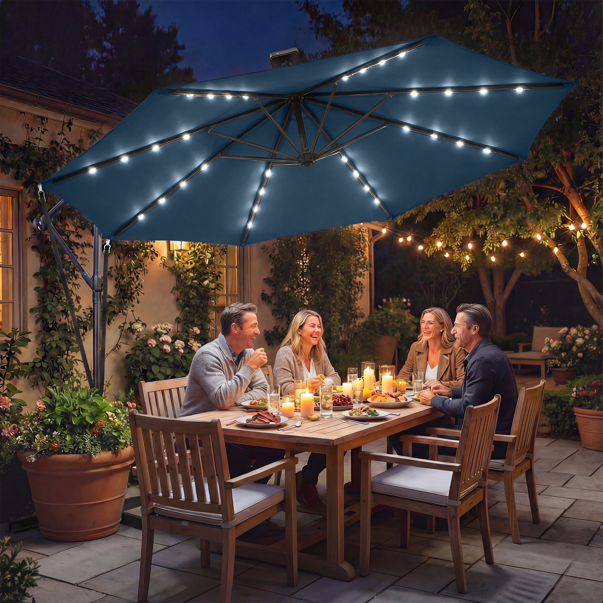 Personas cenando en un patio por la noche bajo una sombrilla iluminada.