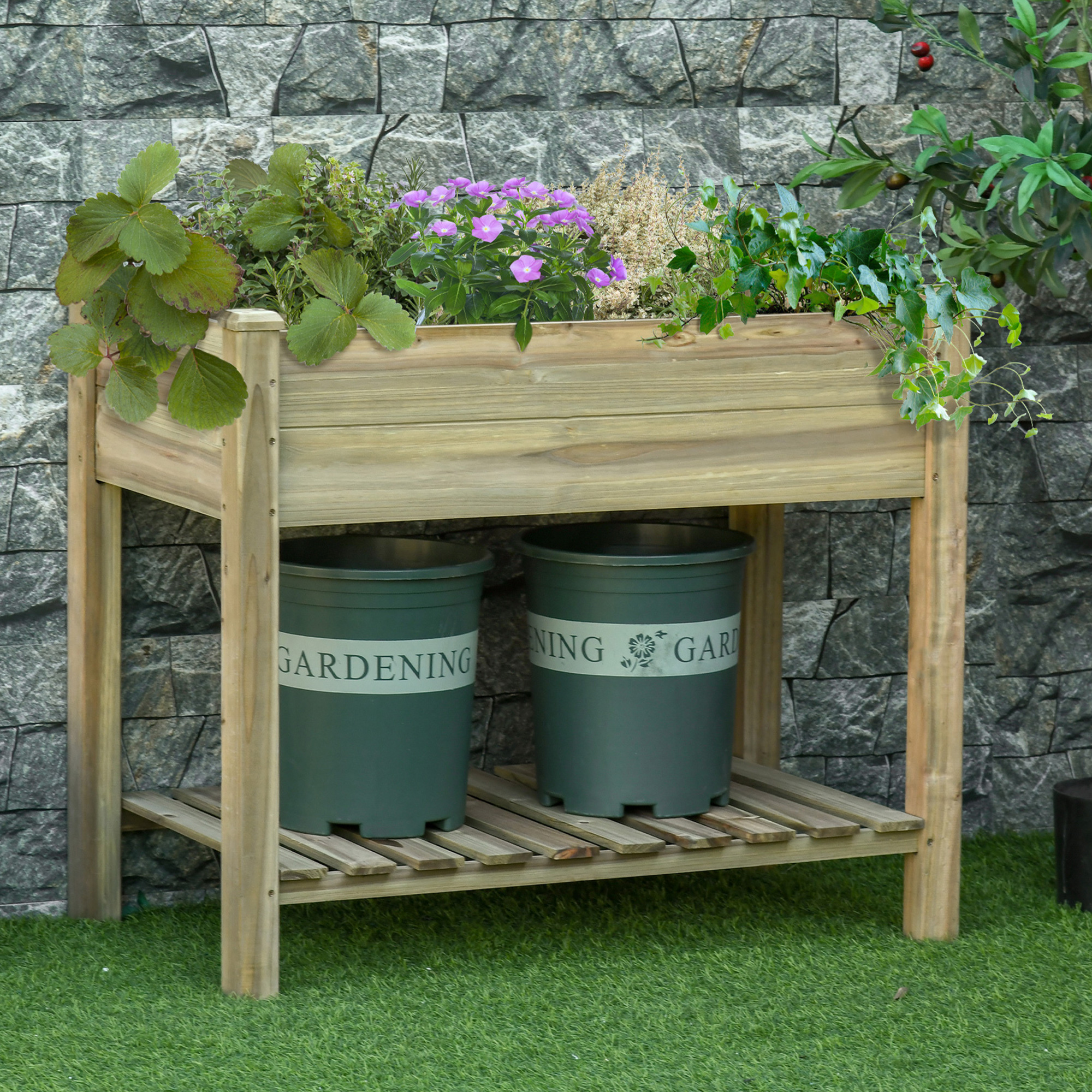 Un bancal elevado de madera con plantas y dos macetas verdes debajo.