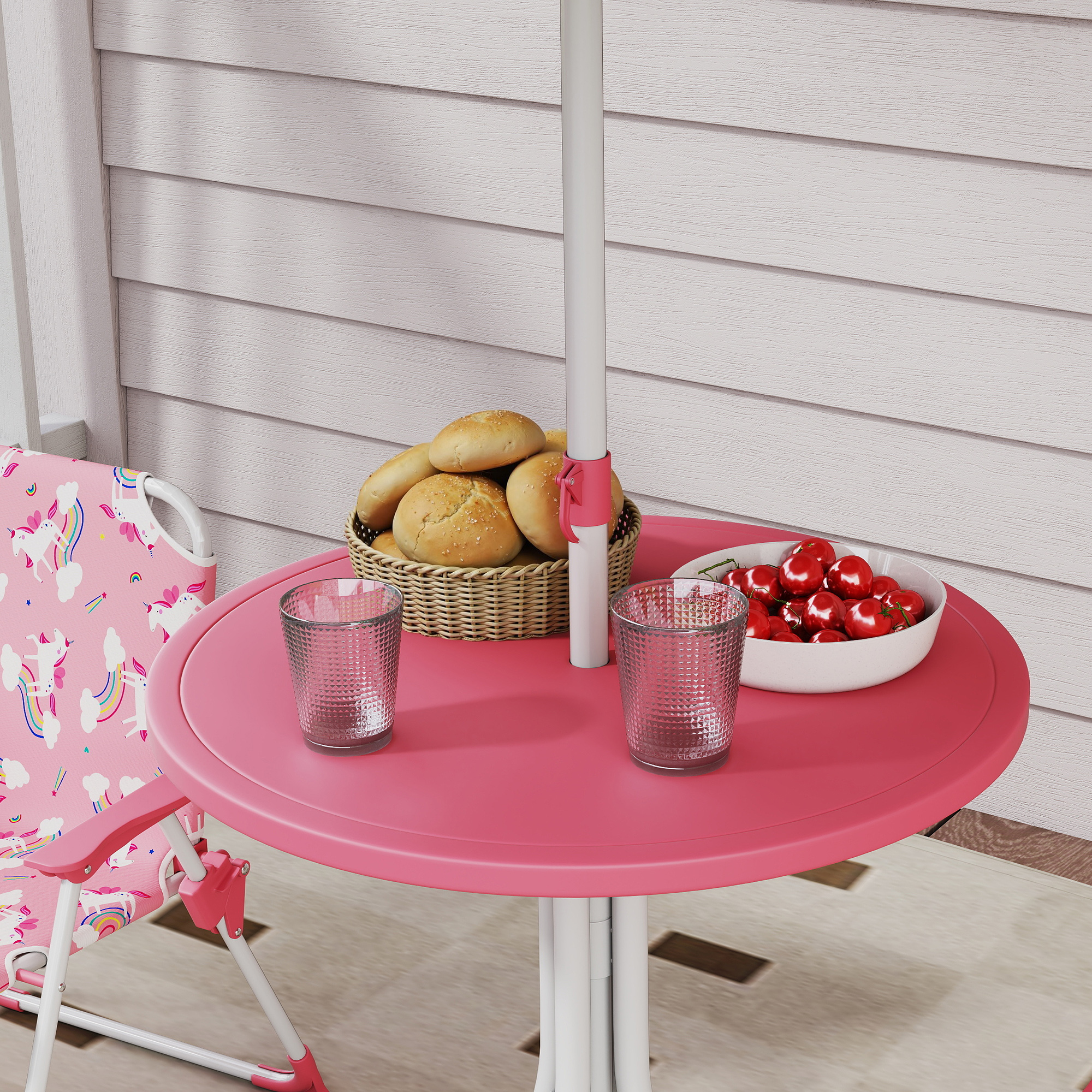 Un tavolo rosa con bicchieri, pane in un cesto e ciliegie.
