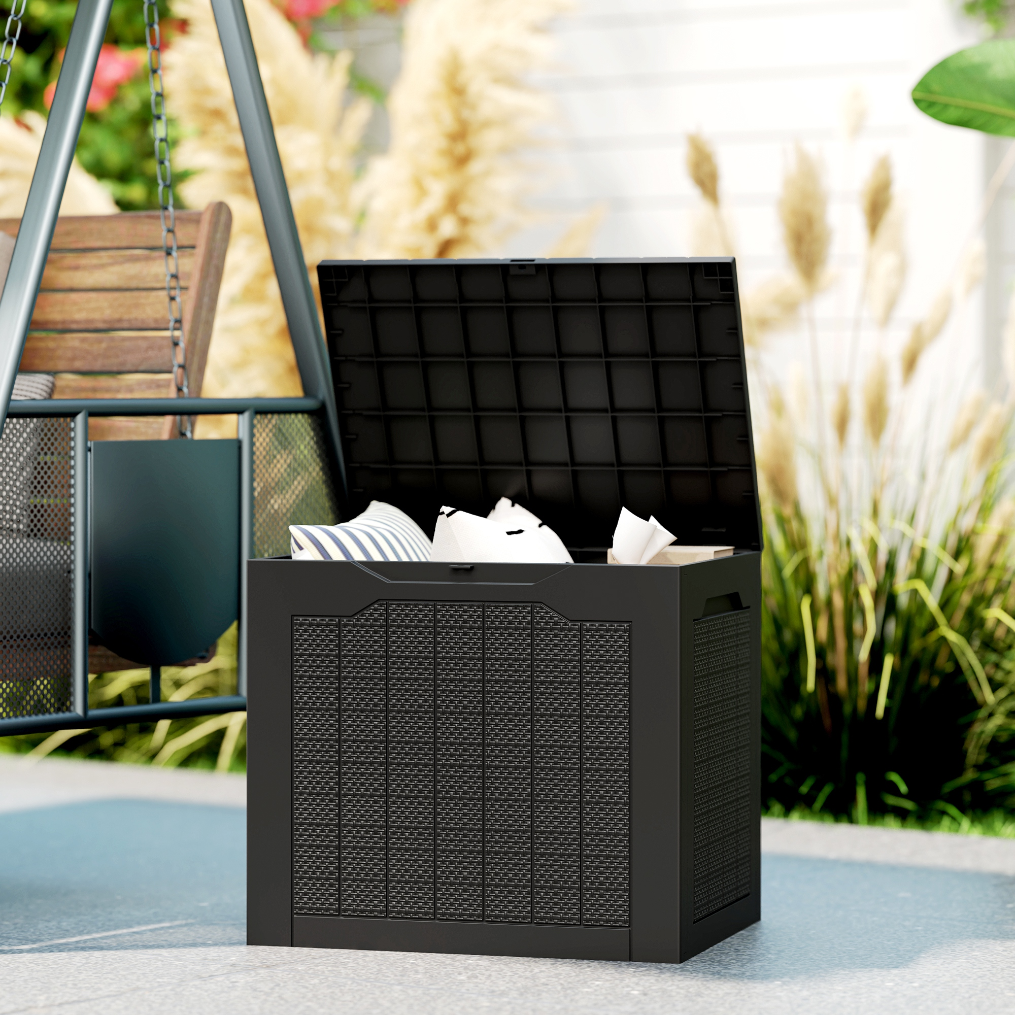 Caja de almacenamiento negra con tapa abierta junto a un columpio. Cojines y papel están dentro.