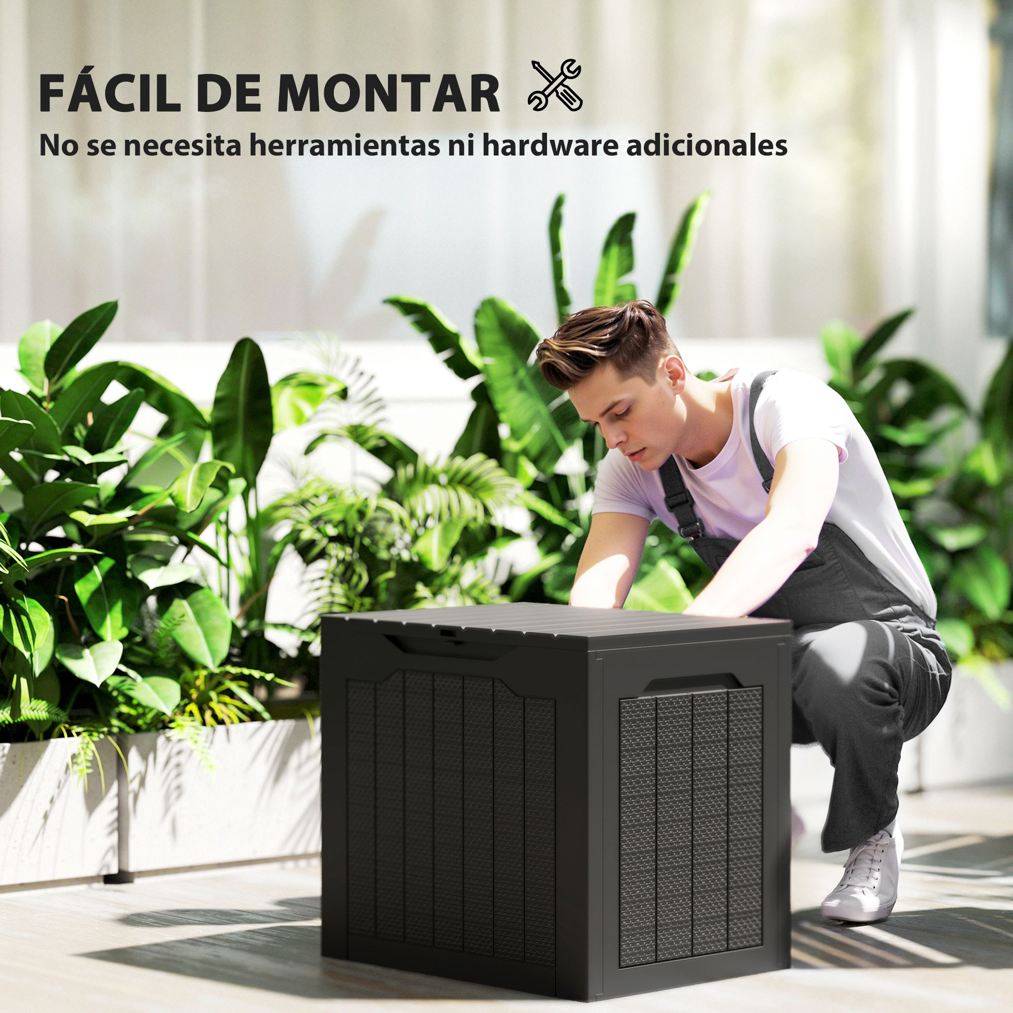 Un hombre arma una caja de almacenamiento negra cerca de plantas.