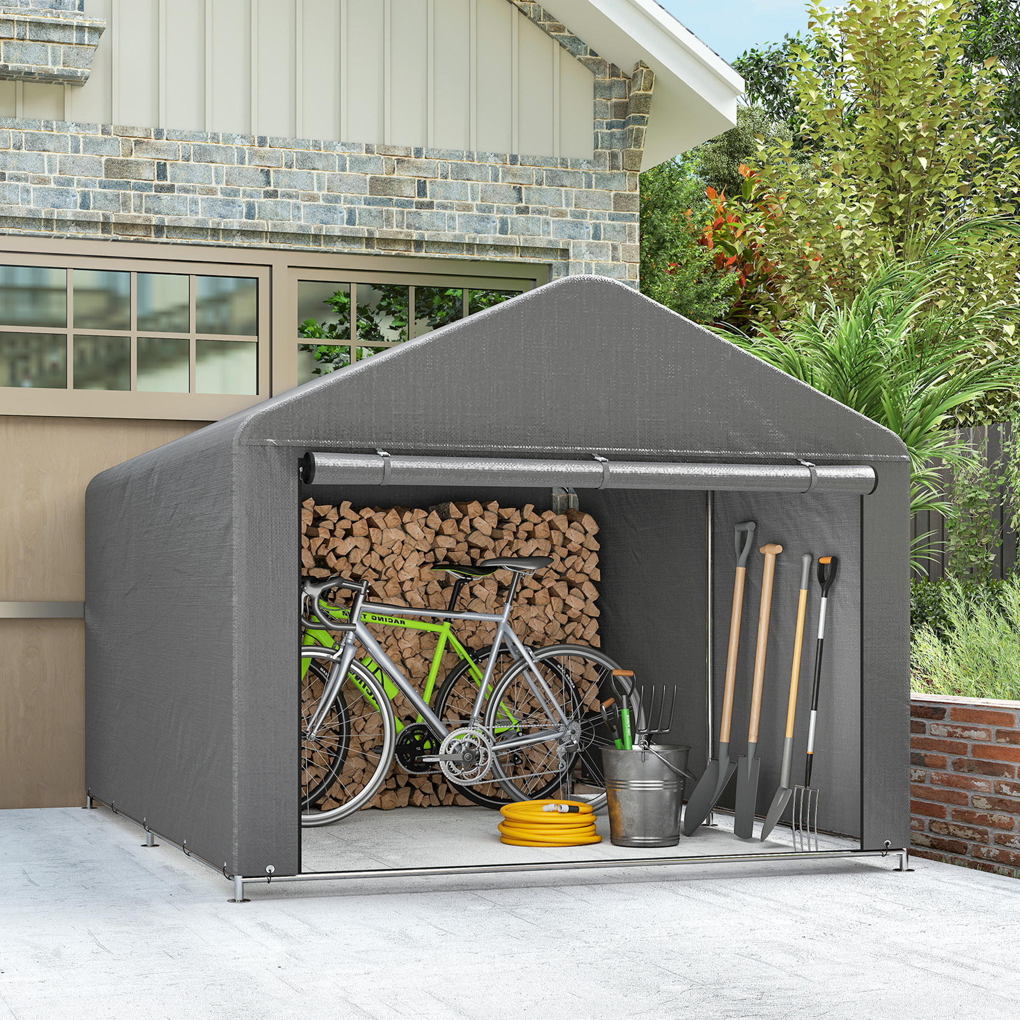 Una tenda portaoggetti grigia con bicicletta, legna e attrezzi da giardino.