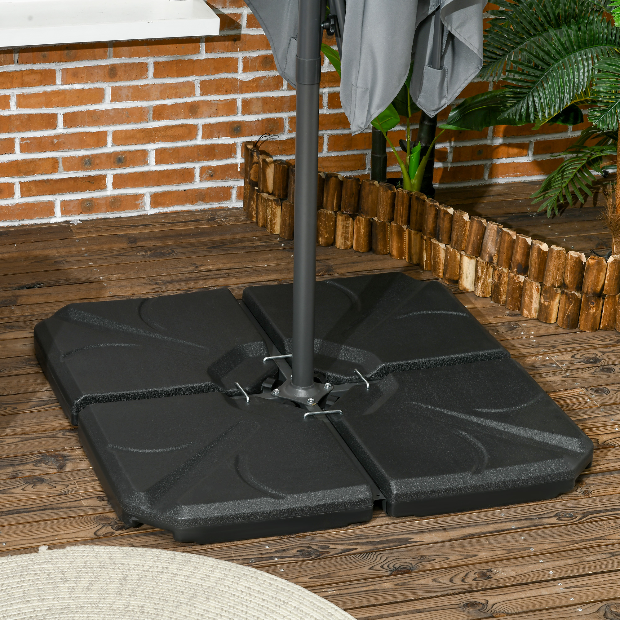 Un soporte de sombrilla gris con cuatro bases negras sobre tarimas de madera.