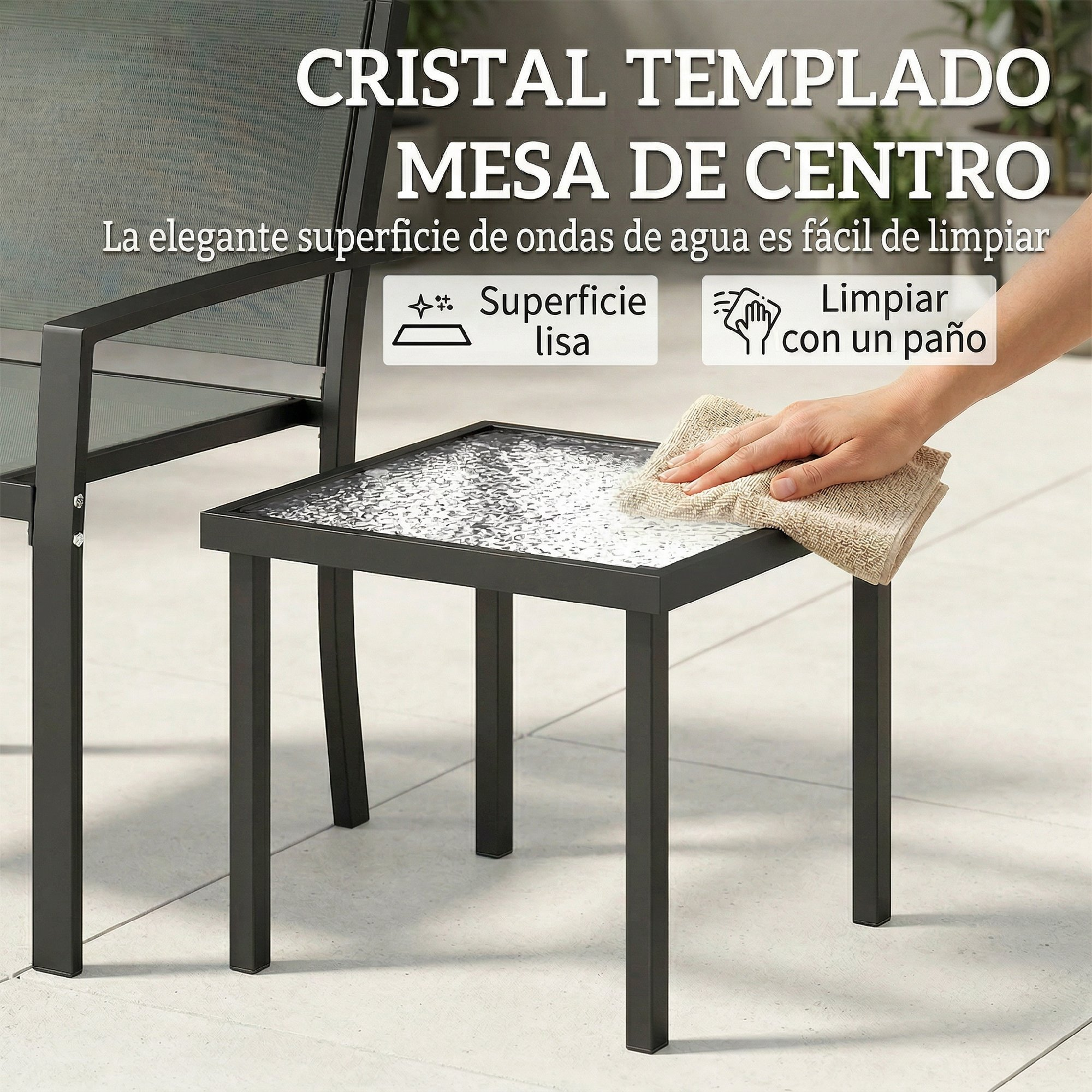 Una mano limpia un tablero de mesa negro de vidrio con un paño.