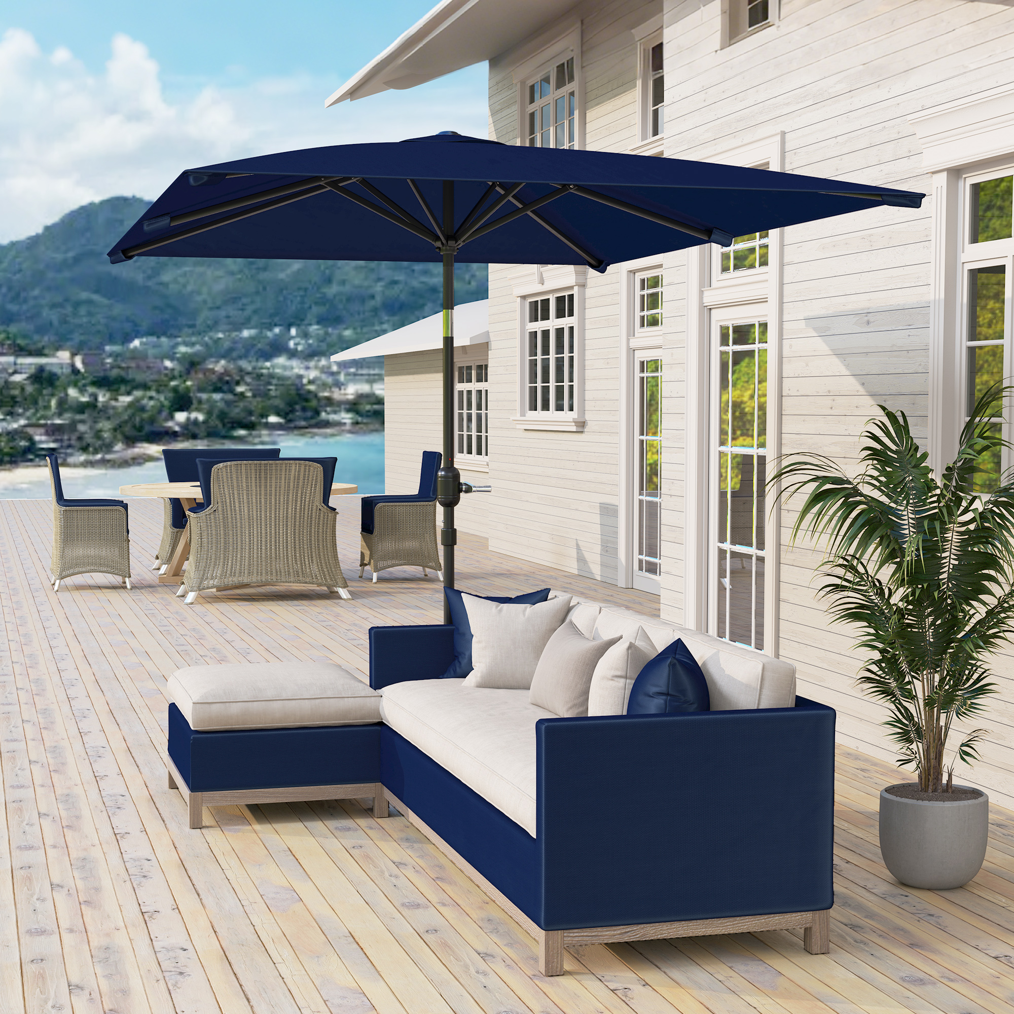 Un sofá azul marino en forma de L con cojines color crema sobre una terraza de madera.