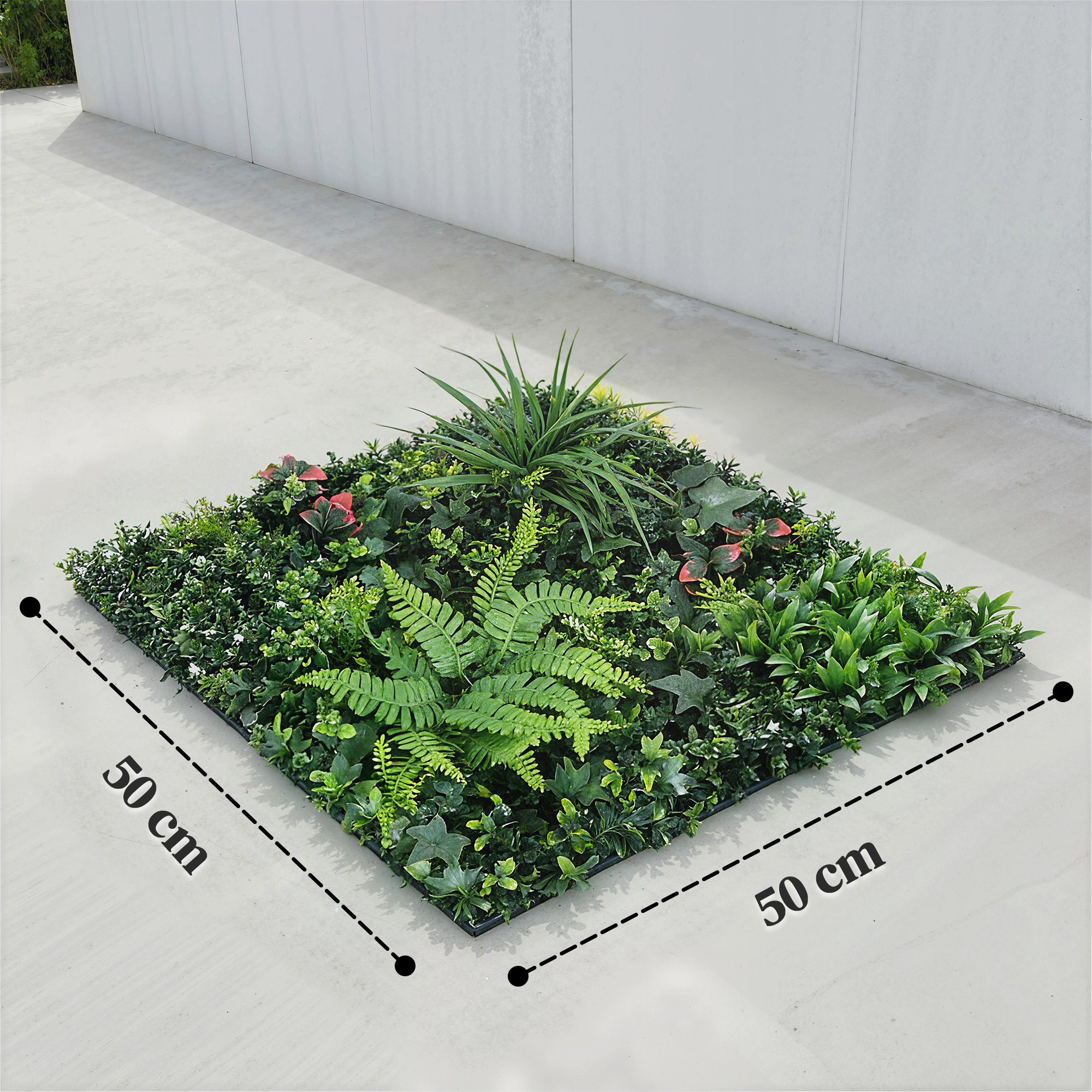 Un panel de plantas artificiales denso de 50x50 cm con helechos y hojas rojas.