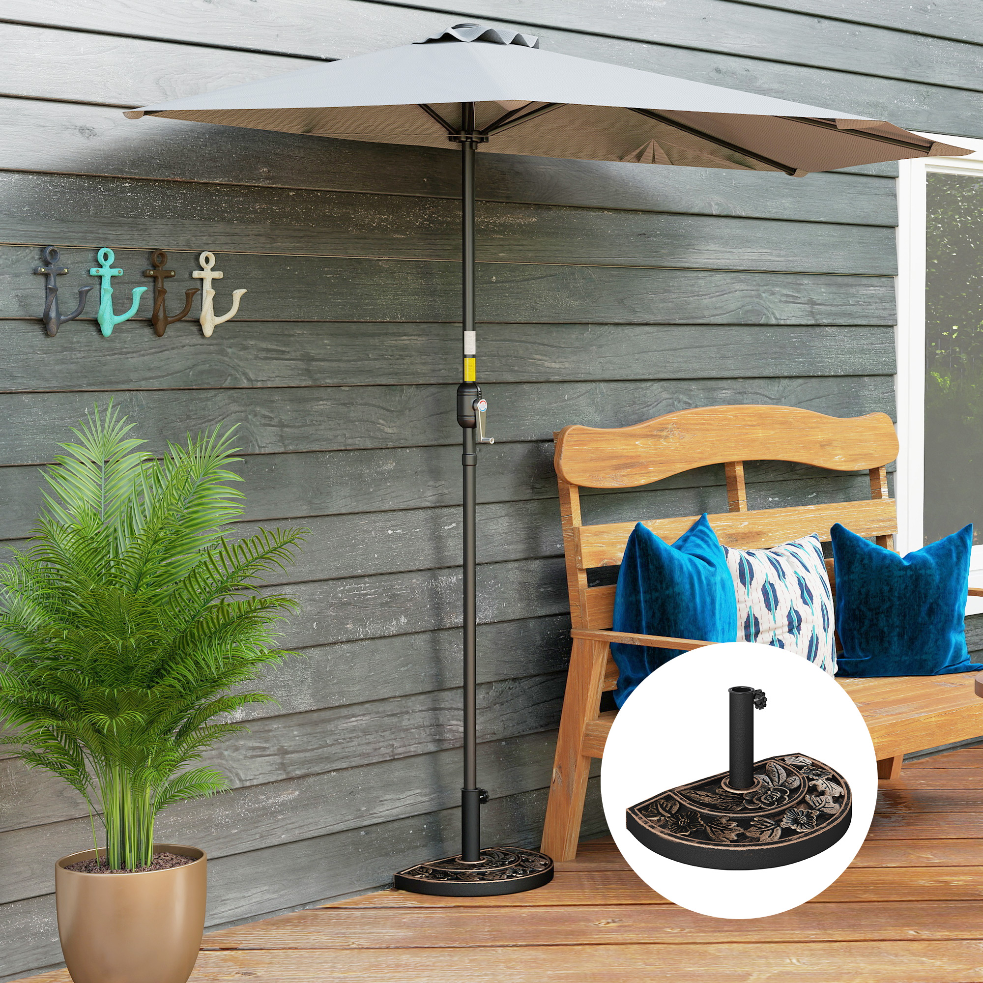 Una sombrilla de patio gris con base floral se alza sobre una terraza de madera.