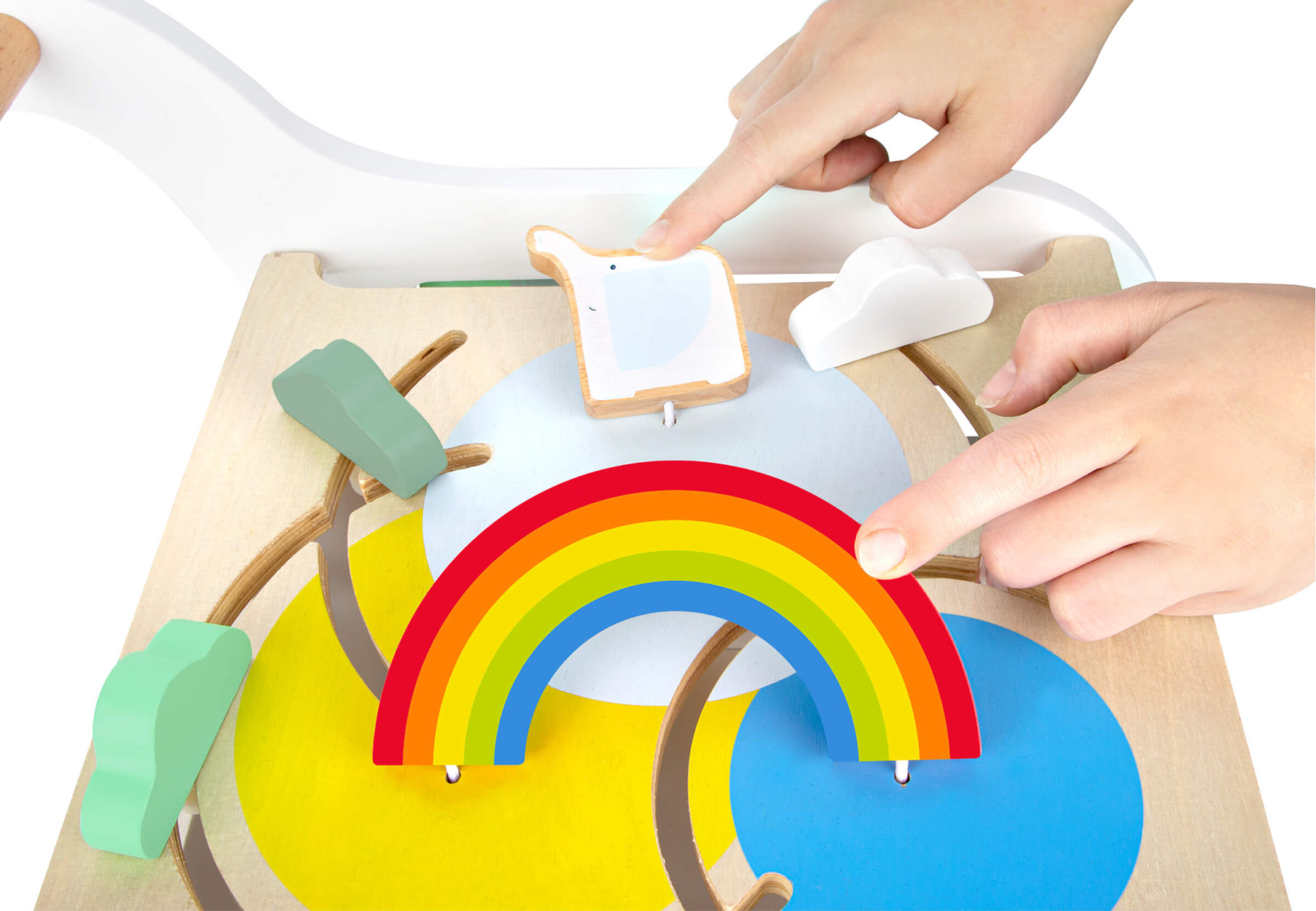 Hände spielen mit einem Holzspielzeug mit Regenbogen, Wolken und Bäumen.