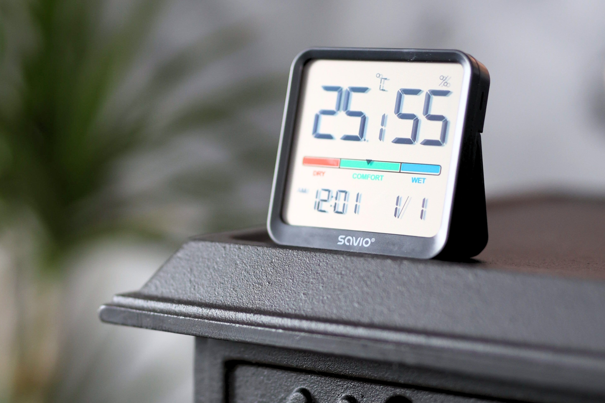 Cyfrowy termometr/higrometr pokazuje 25°C i 55% wilgotności. Godzina 12:01.