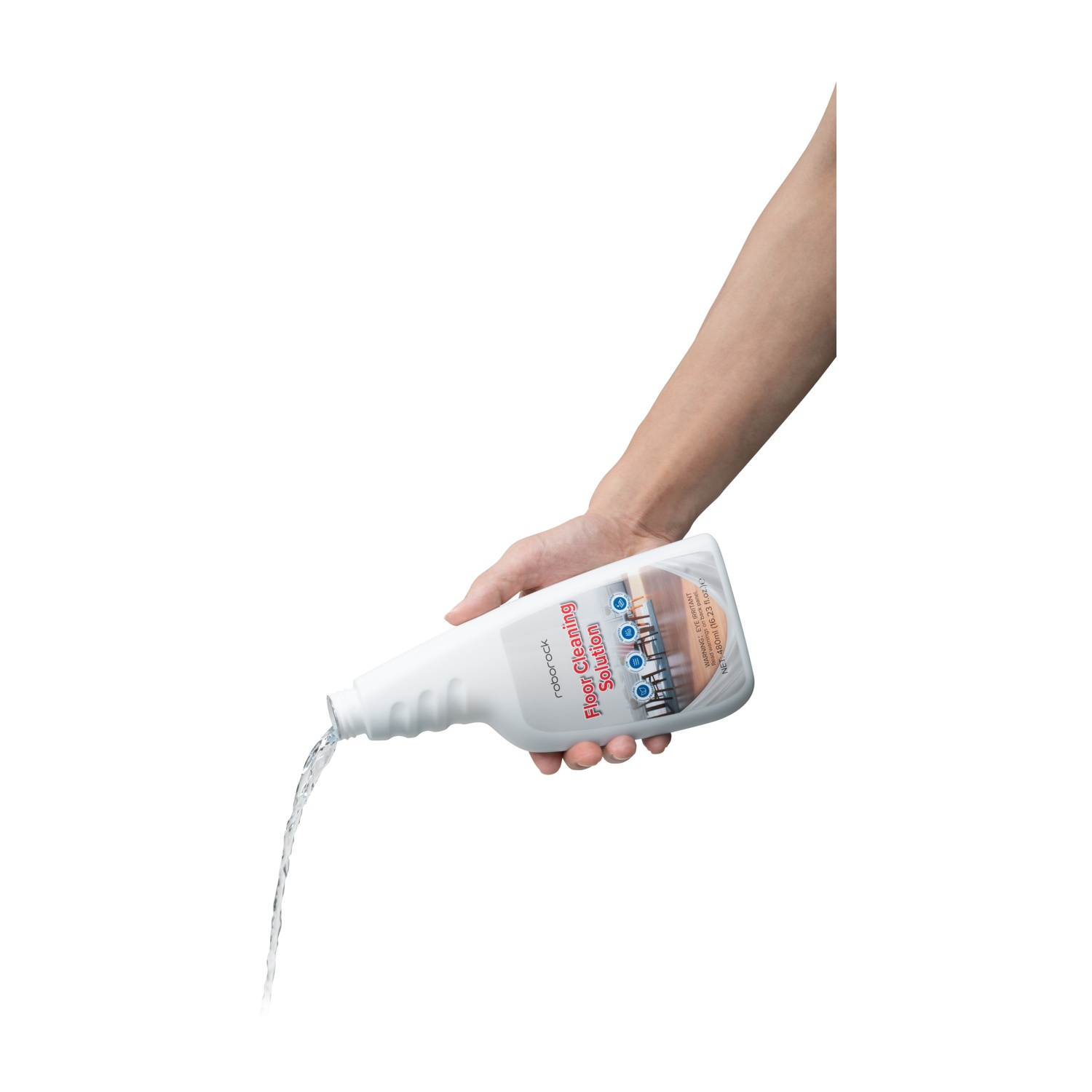 Una mano tiene una bottiglia bianca che versa acqua su un pavimento.