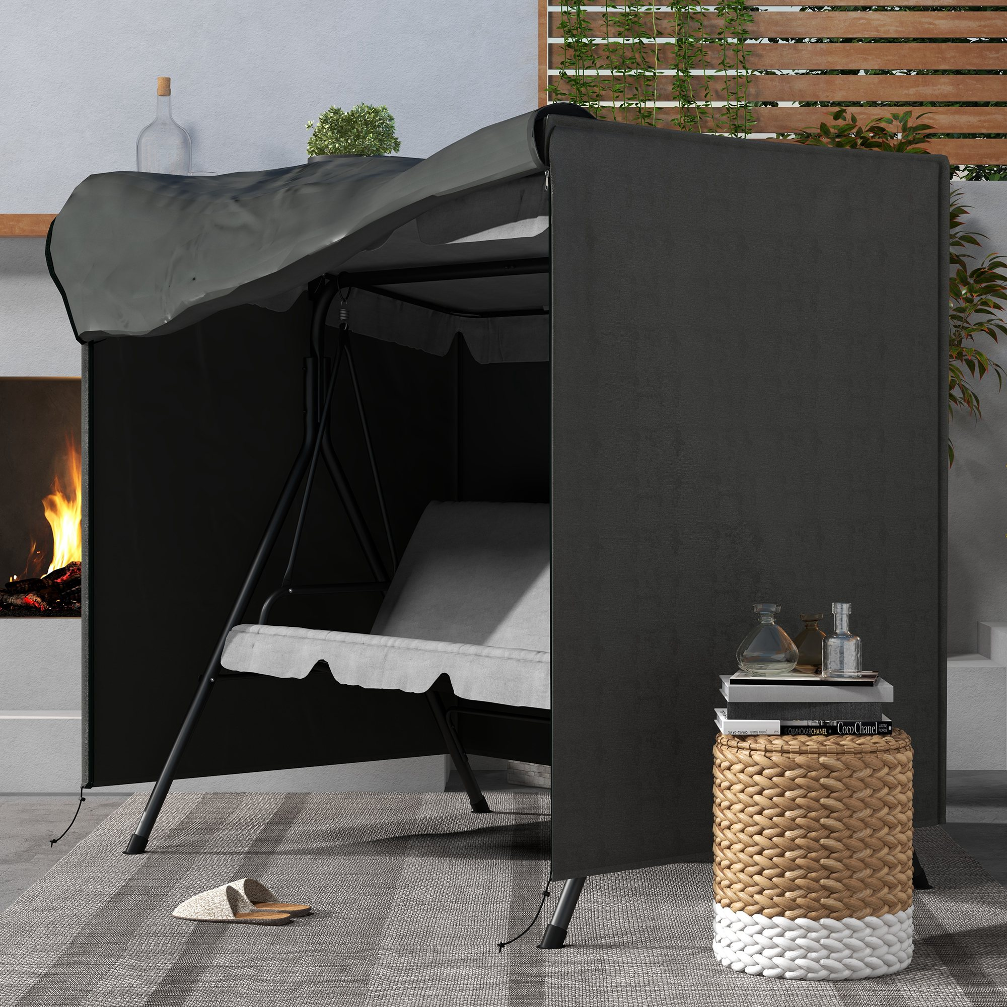 Una mecedora con funda oscura está en un patio junto a una chimenea.