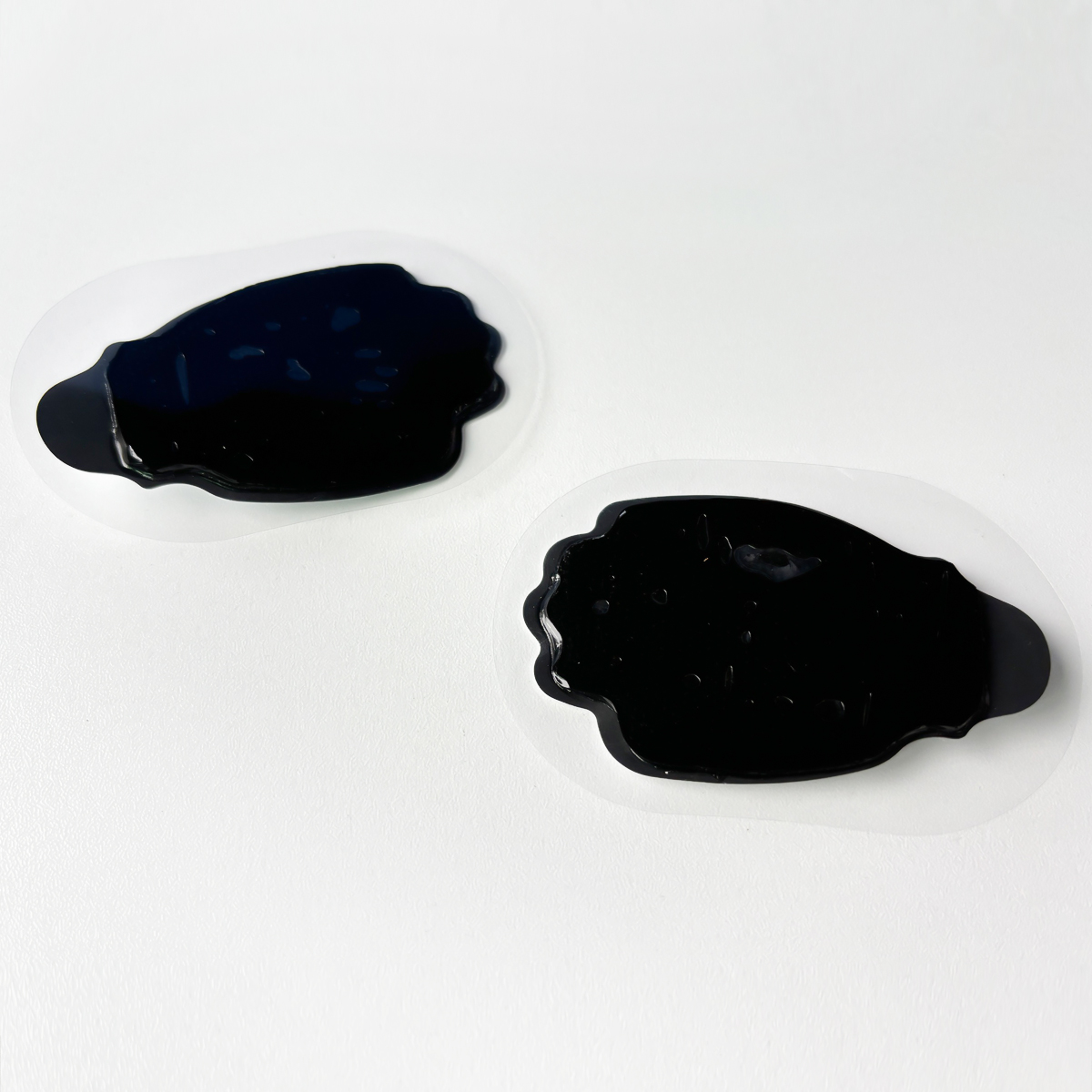 Two irregular black blobs on a white background.