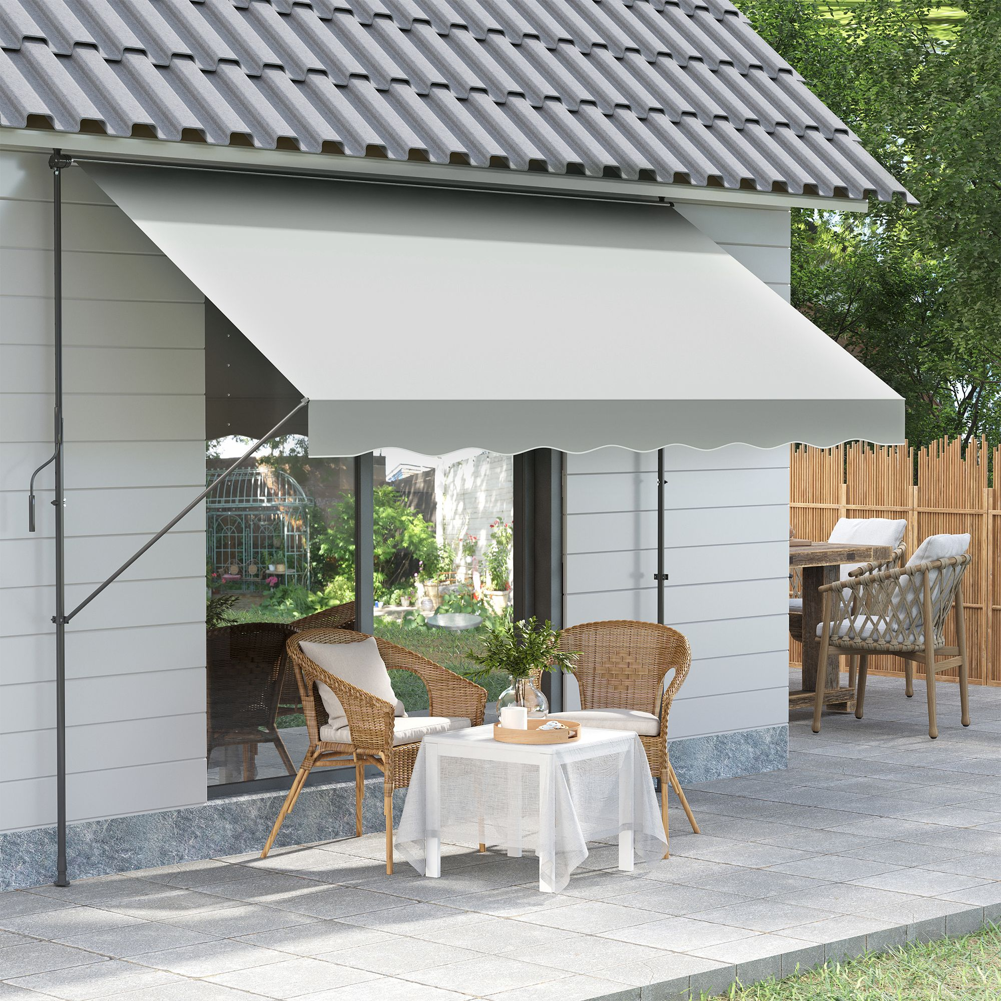 Toldo gris sobre muebles de patio, pared de casa y jardín.